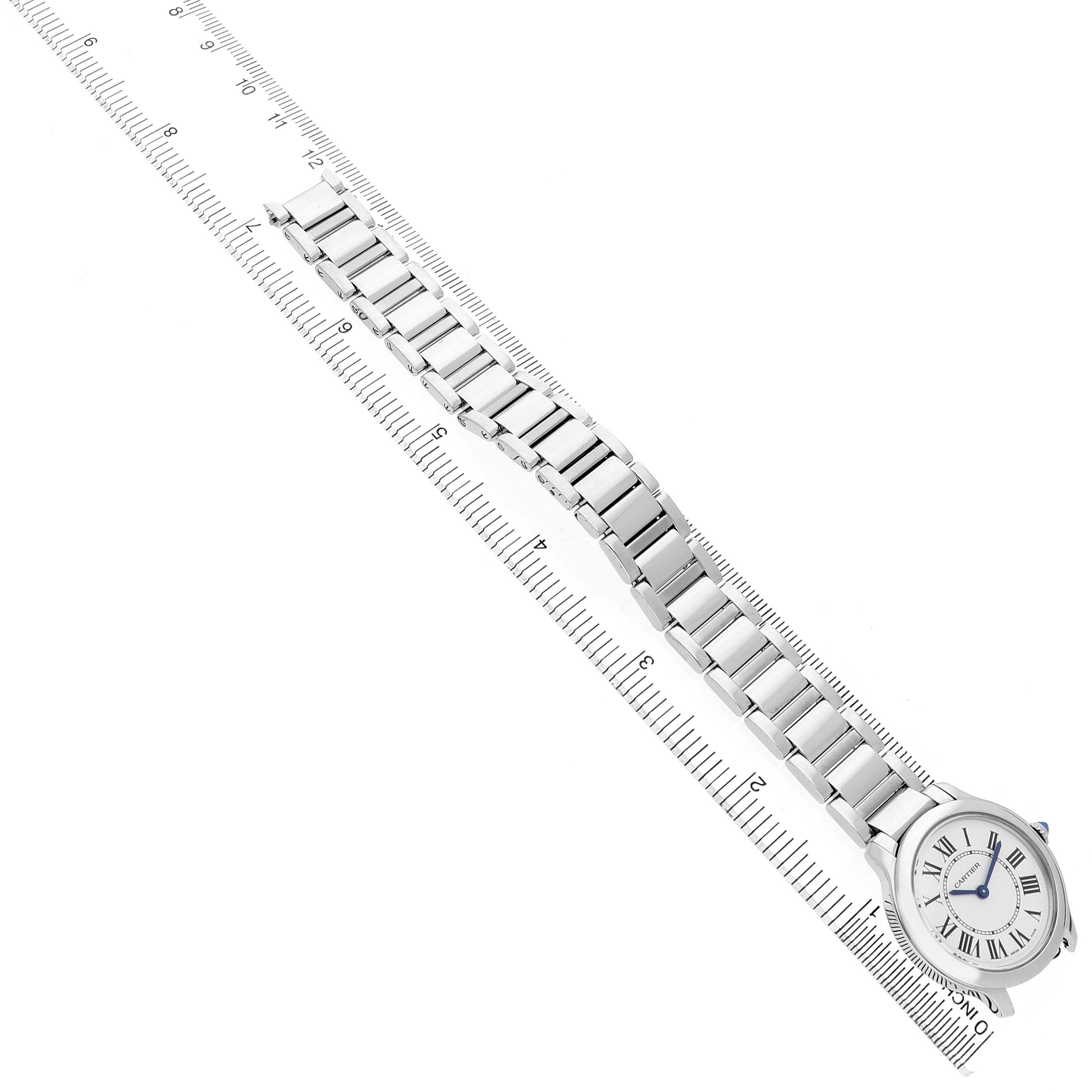 The Cartier Ronde WSRN0033 Women's Stainless Steel White Dial watch is shown from an overhead angle, highlighting its face and metal bracelet aligned with a ruler.