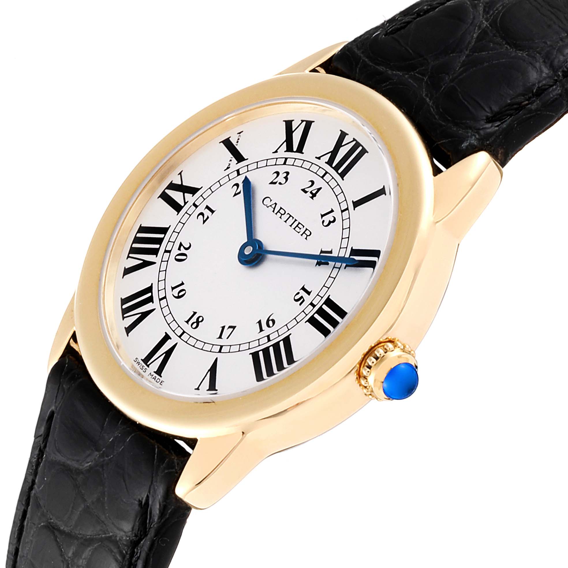The Cartier Ronde W6700355  Women's Yellow Gold Silver Dial W6700355  Women's Yellow Gold Silver Dial watch is shown at a slight angle featuring its face, bezel, crown with a blue cabochon, and black leather strap.