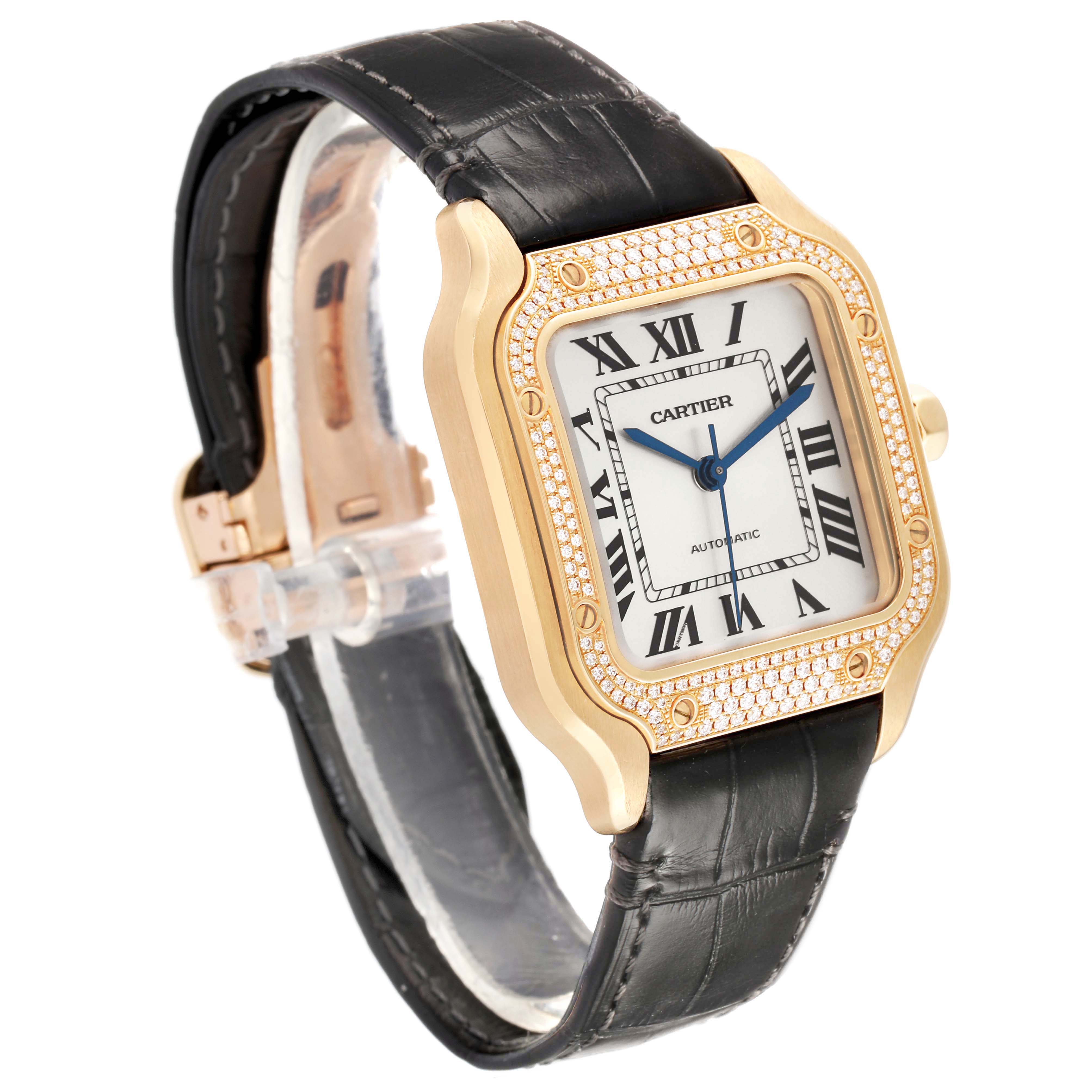 The Cartier Santos WJSA0008 Men's Yellow Gold Silver Dial watch is shown at a three-quarter angle, highlighting its square face, Roman numerals, and black strap.