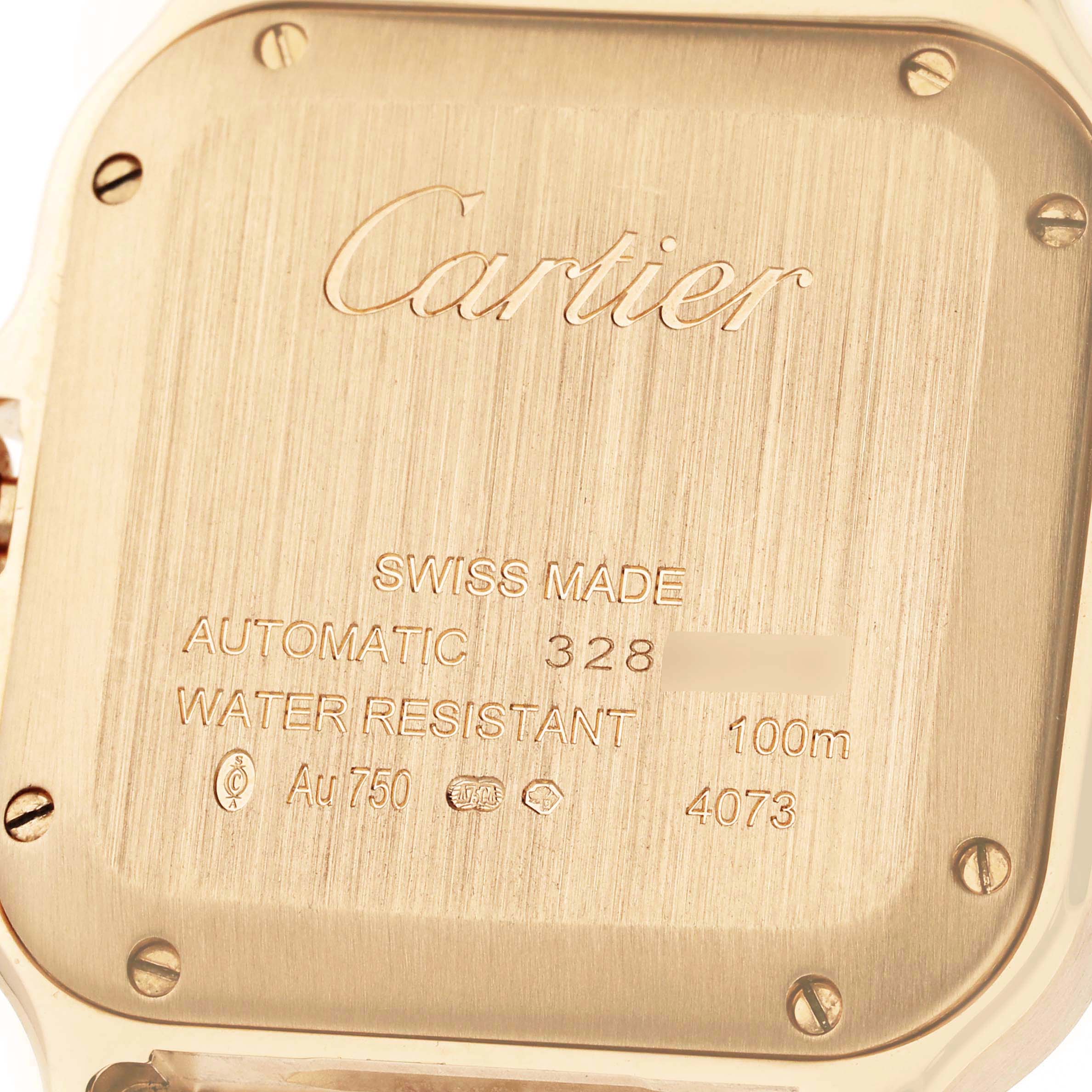 The image shows the back case of a Cartier Santos WJSA0008 Men's Yellow Gold Silver Dial watch, highlighting details like water resistance and material.