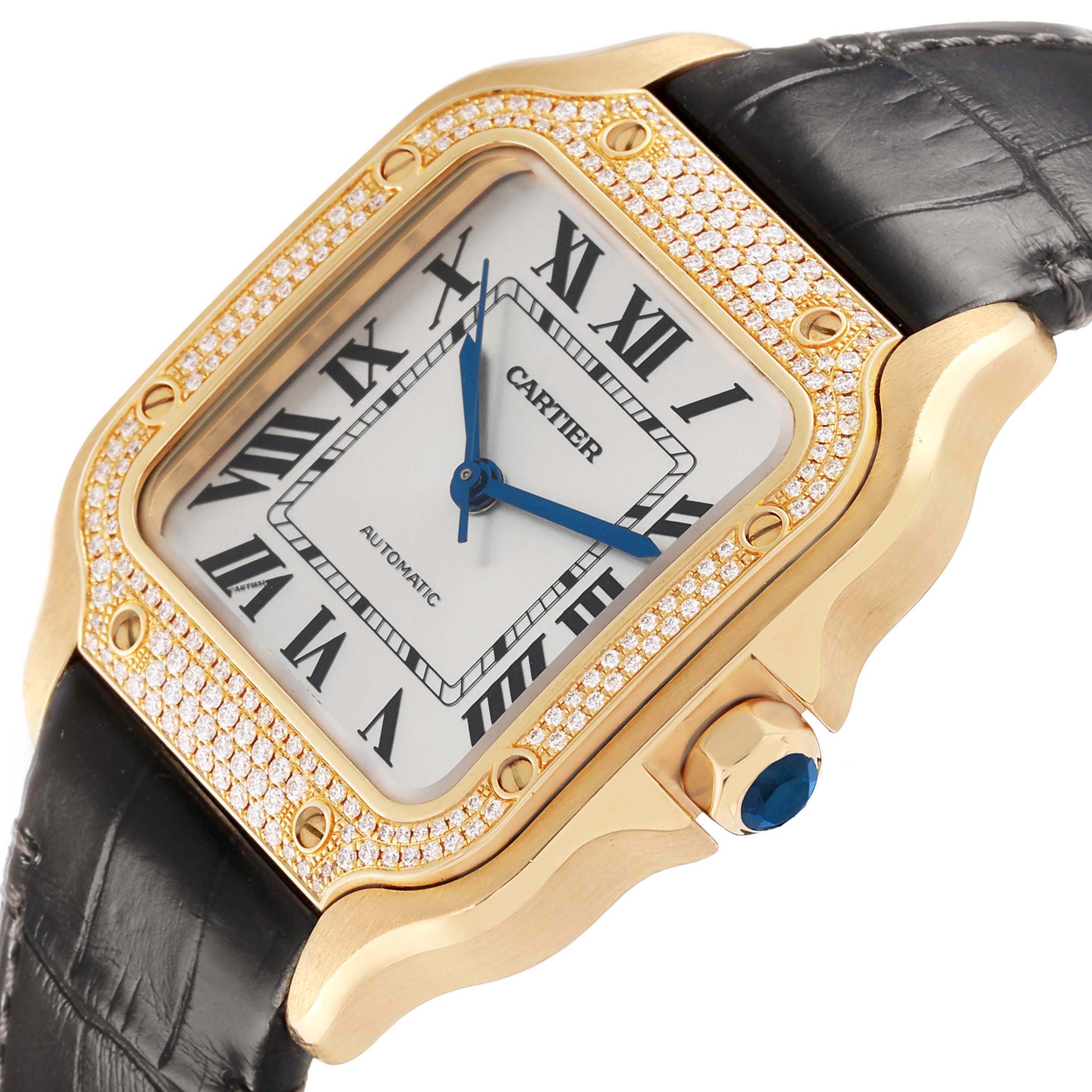 The Cartier Santos WJSA0008 Men's Yellow Gold Silver Dial watch is shown at an angled view, highlighting the diamond-encrusted bezel, Roman numeral dial, and crown with a blue gem.