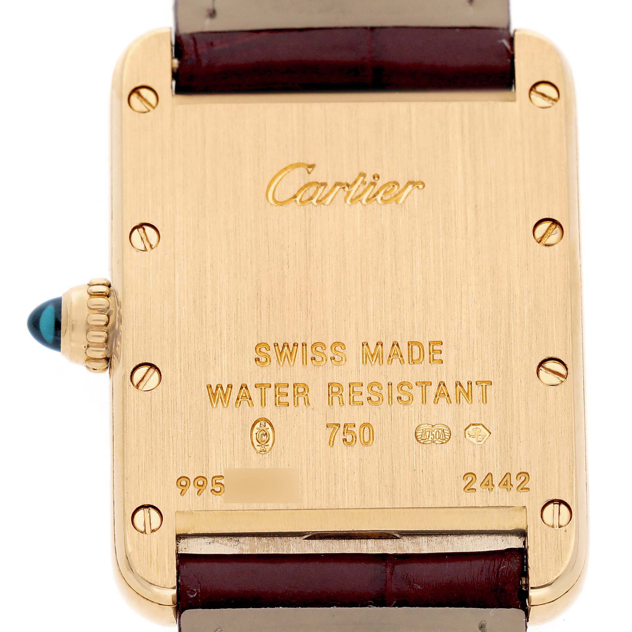 The image shows the back of a Cartier Tank Louis W1529856 Men's Yellow Gold Silver Dial watch, highlighting engravings and the crown with a blue cabochon.