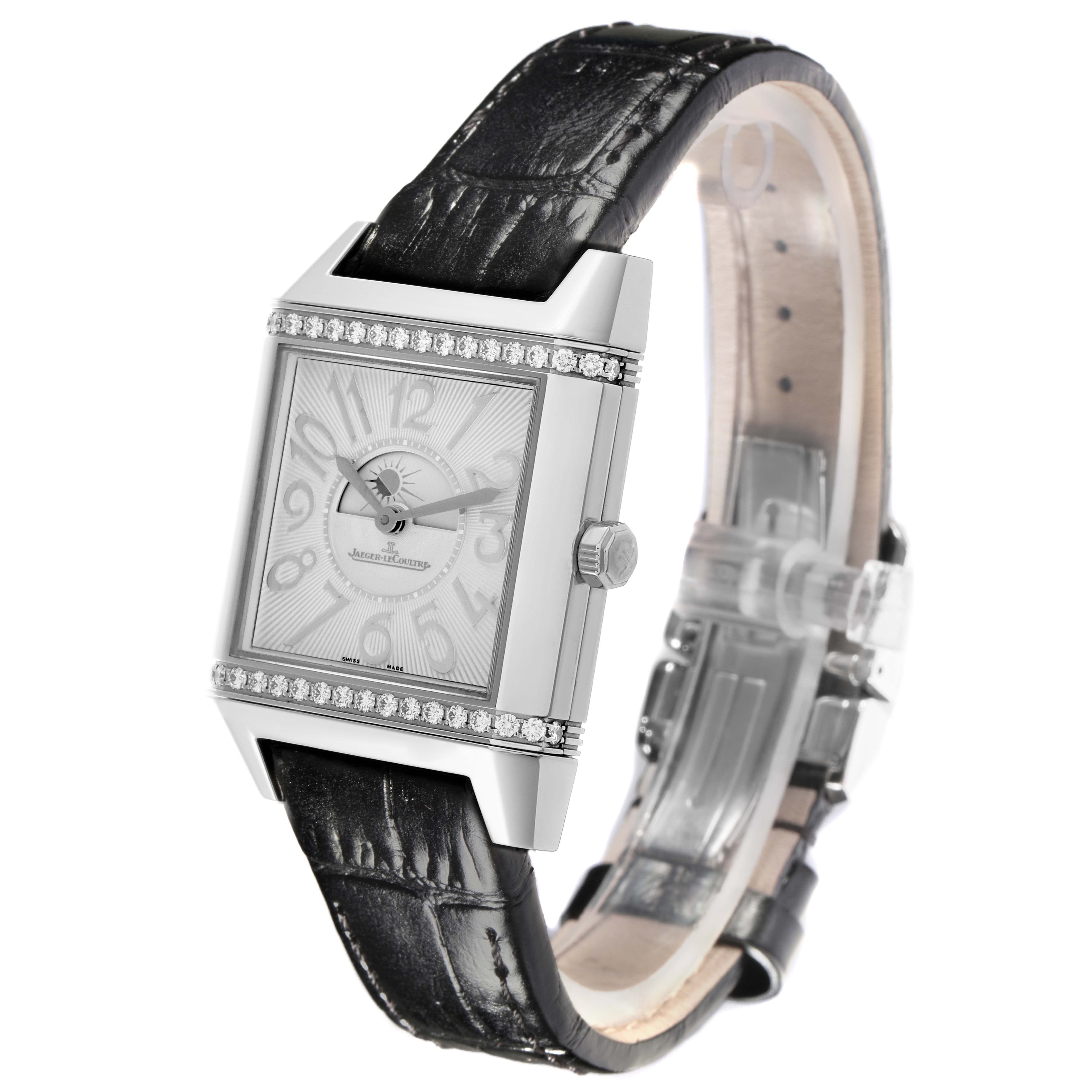 The Jaeger-LeCoultre Reverso watch is shown at an angle highlighting the face, case, crown, and black leather strap.