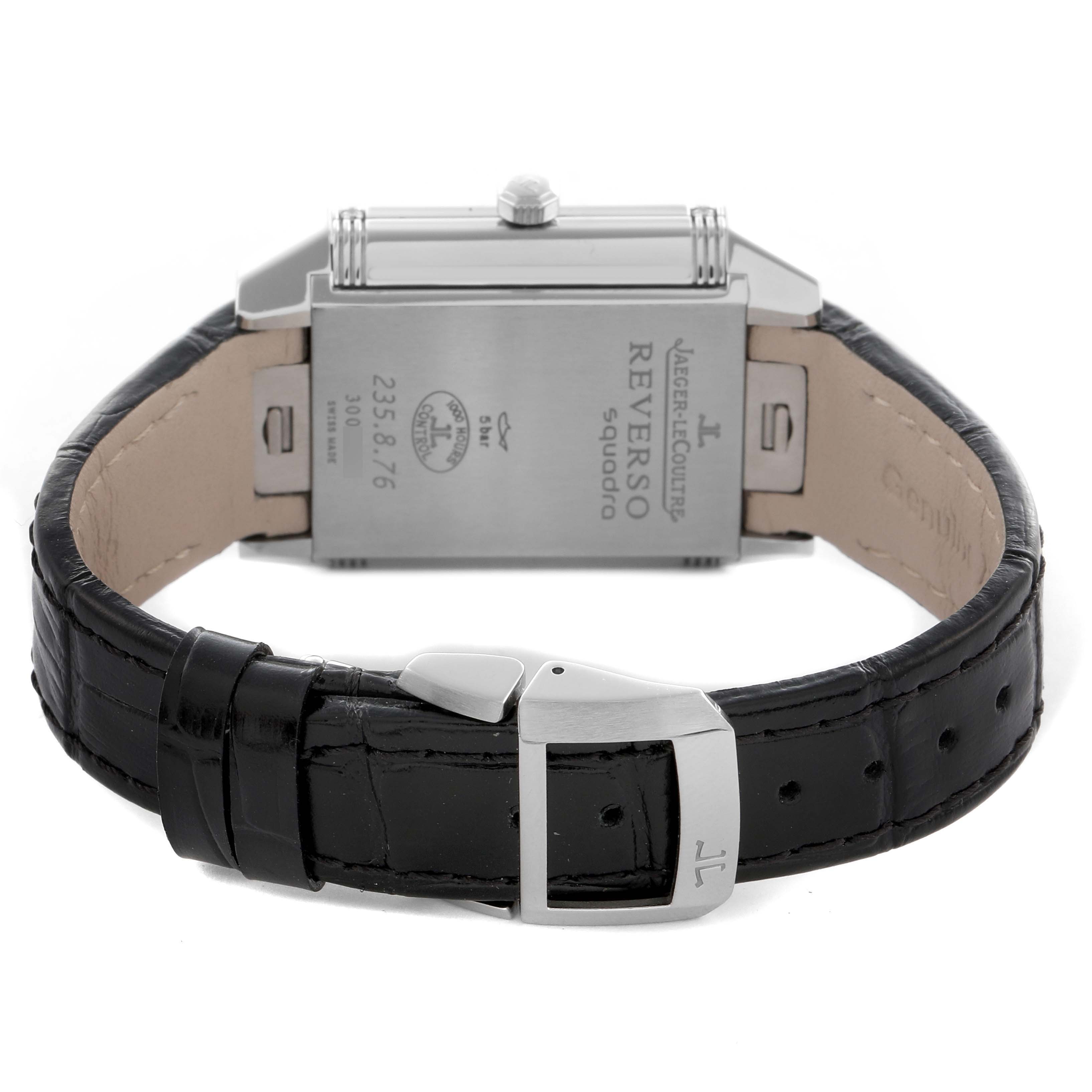 The Jaeger-LeCoultre Reverso watch is shown from the back, highlighting the case back and leather strap with a buckle.
