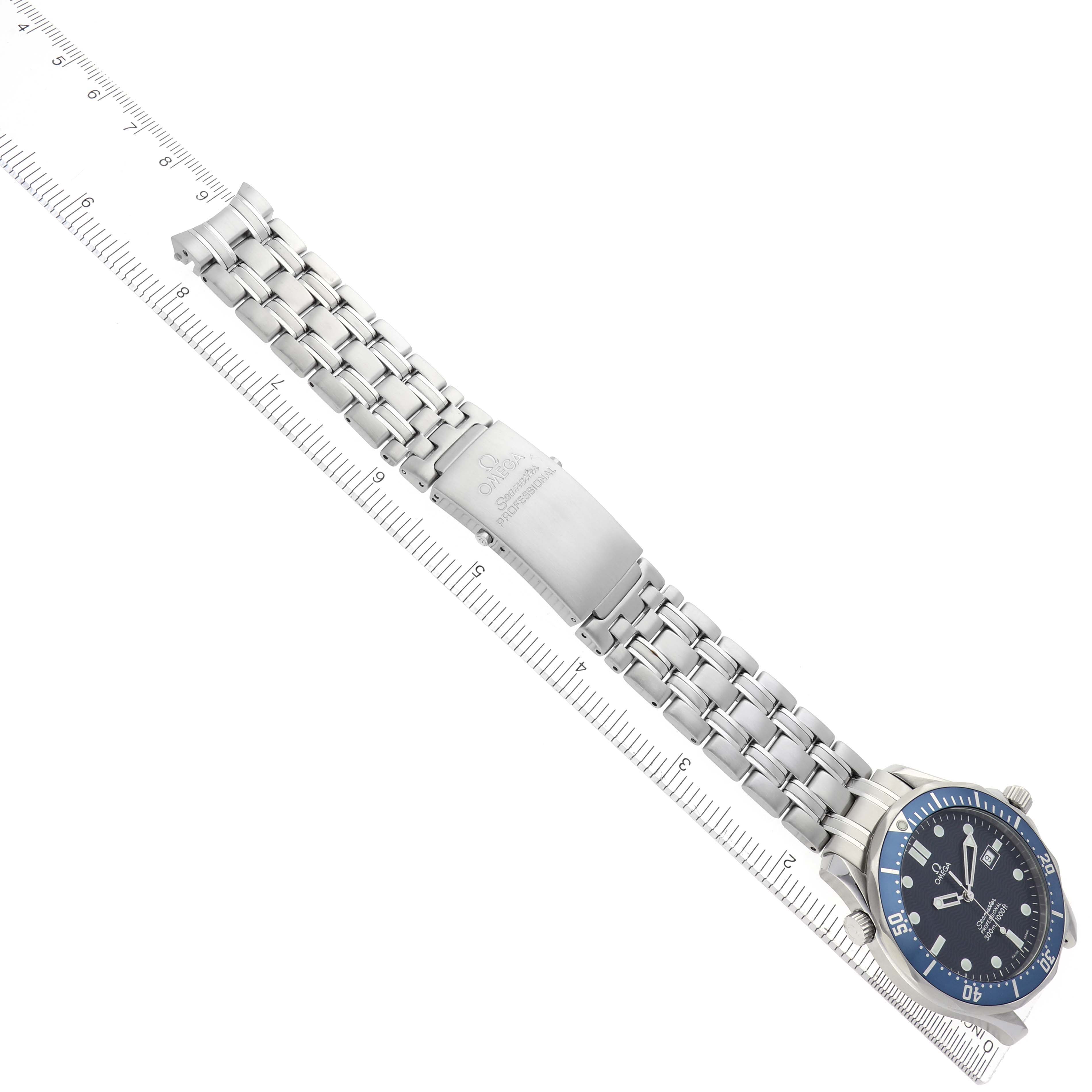 The Omega Seamaster 2541.80.00 Men
s Stainless Steel Blue Dial 2541.80.00 Men
s Stainless Steel Blue Dial watch is shown at a top-down angle, displaying the face, bracelet, and clasp alongside a ruler for scale.