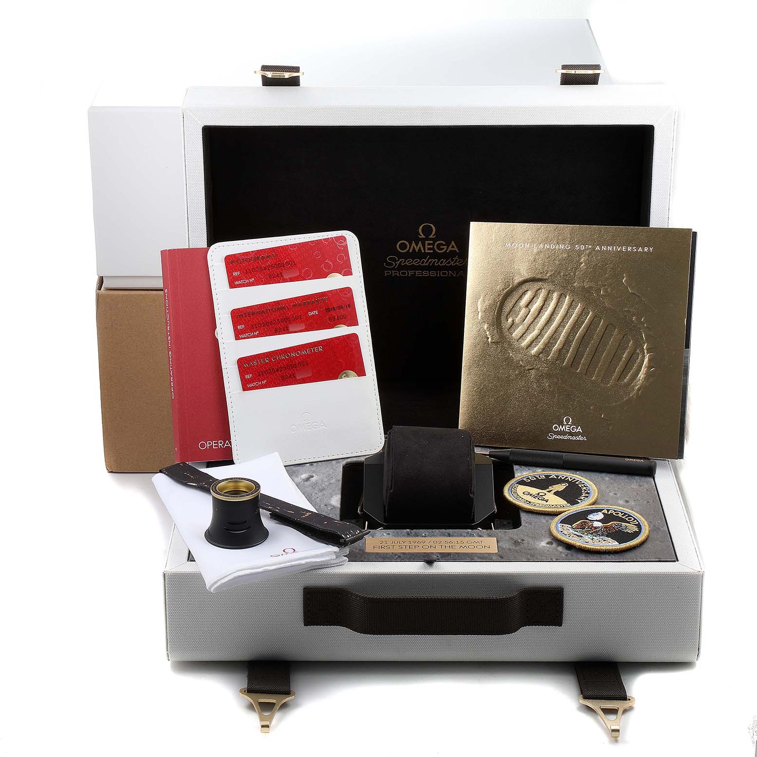 This image shows the Omega Speedmaster 310.20.42.50.01.001 Men's Stainless Steel Grey Dial 310.20.42.50.01.001 Men's Stainless Steel Grey Dial watch packaging, accessories, booklets, and special edition items from a frontal angle.