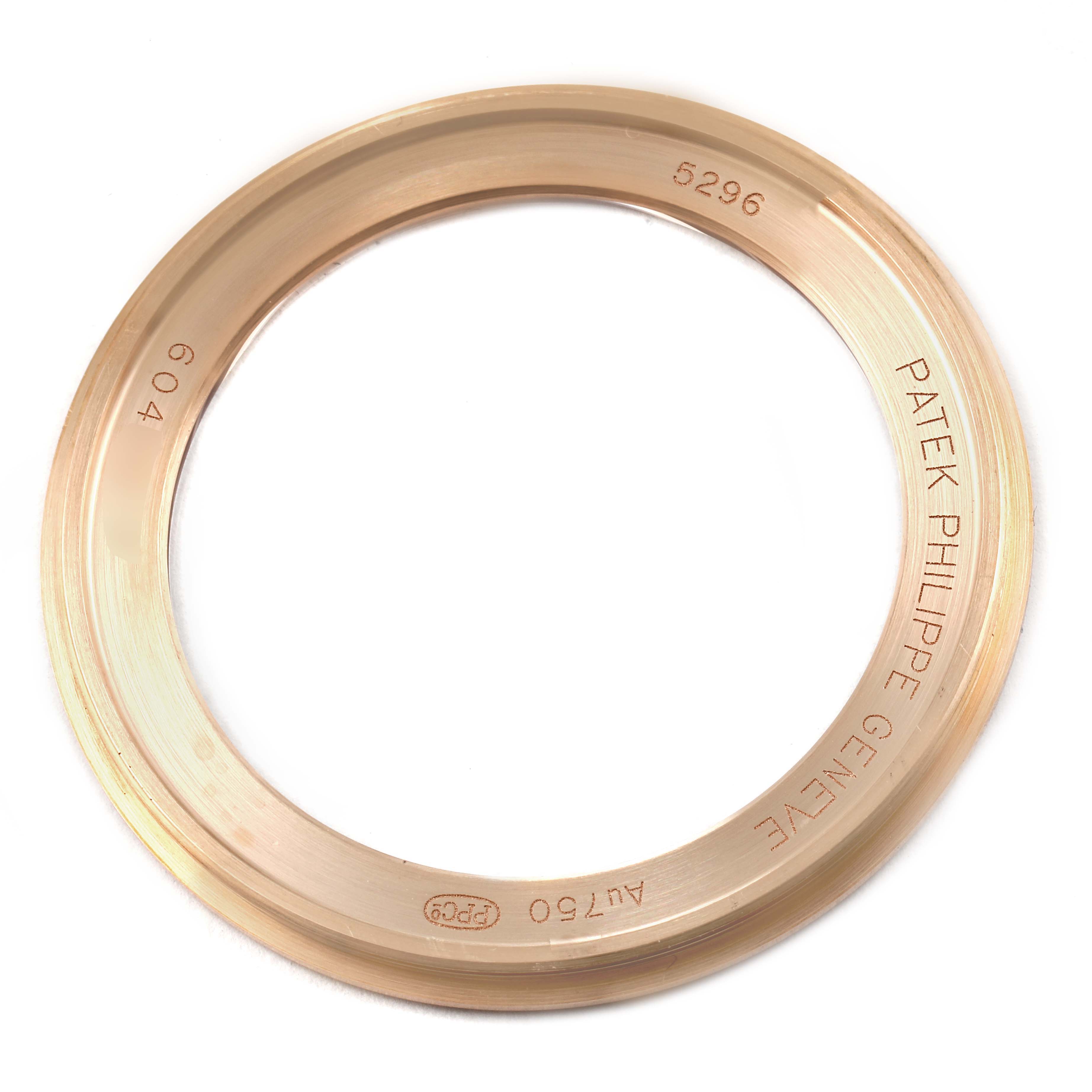 The image shows a close-up of a gold bezel from a Patek Philippe Calatrava 5296R-010 Men
s Rose Gold Silver Dial 5296R-010 Men
s Rose Gold Silver Dial watch model.