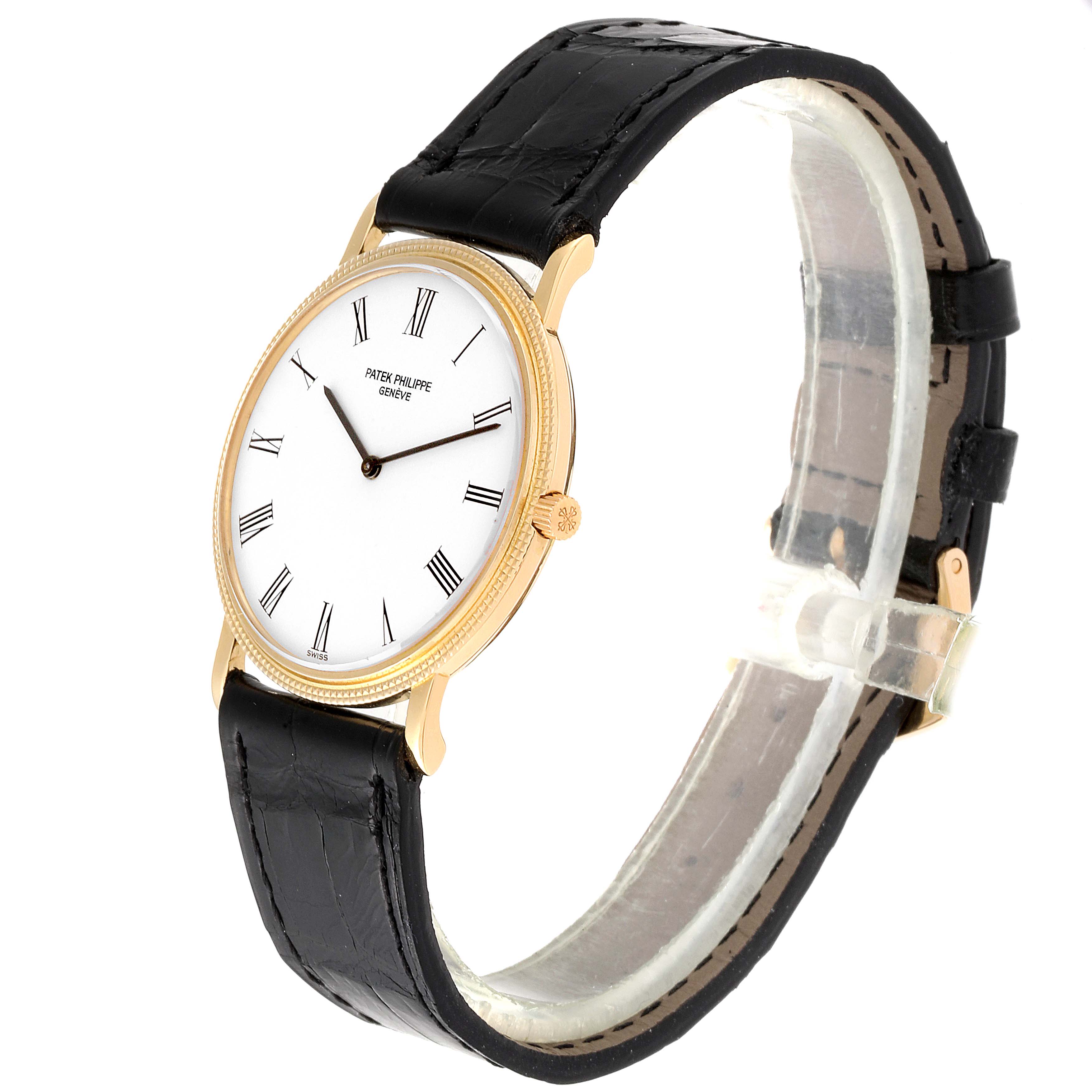 This Patek Philippe Calatrava 3520 Men's Yellow Gold White Dial 3520 Men's Yellow Gold White Dial model watch is shown at a side angle, highlighting its face, crown, and black leather strap.