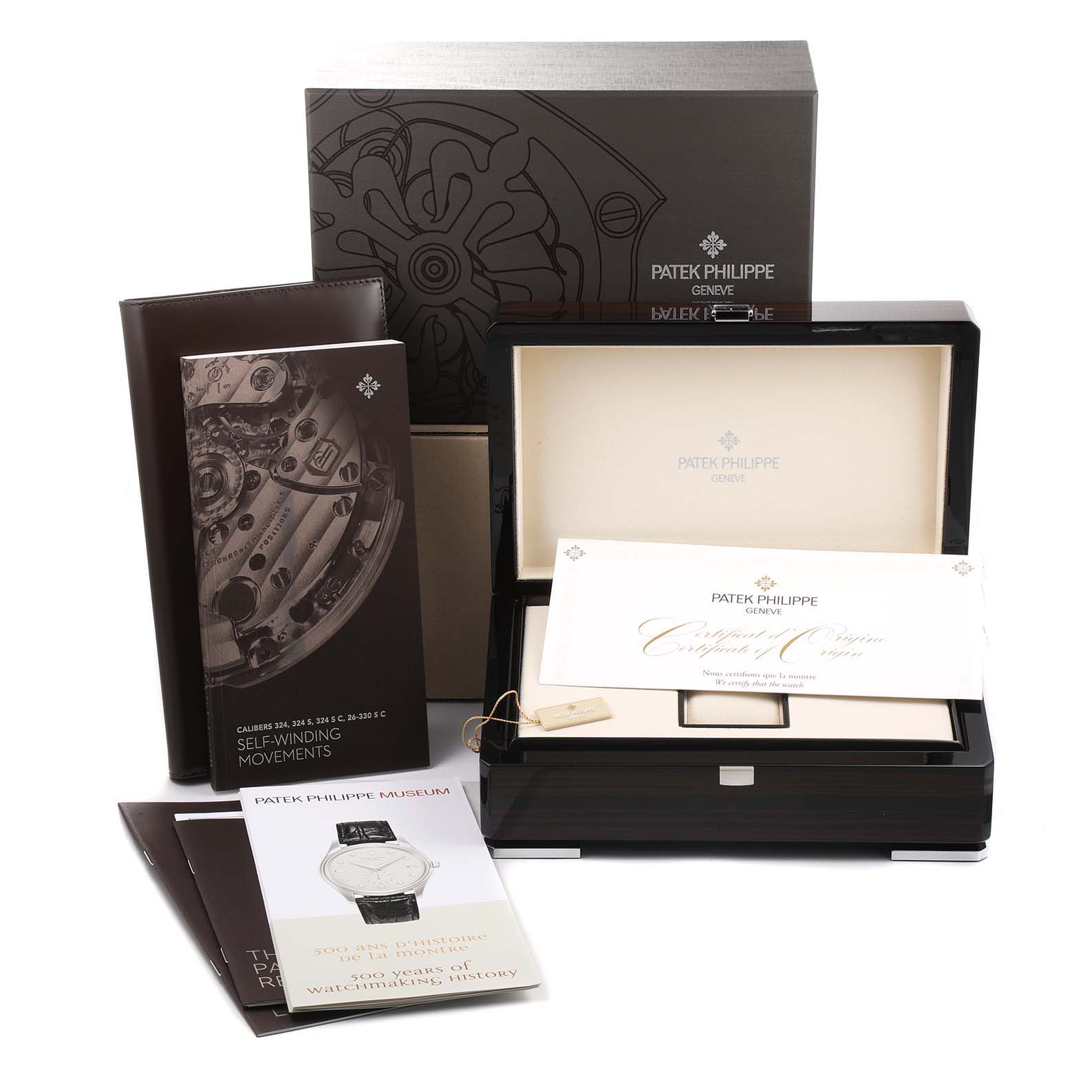 The image shows accessories for the Patek Philippe Calatrava 5227G Men
s White Gold Black Dial 5227G Men
s White Gold Black Dial model, including a watch box, booklets, and a certificate.