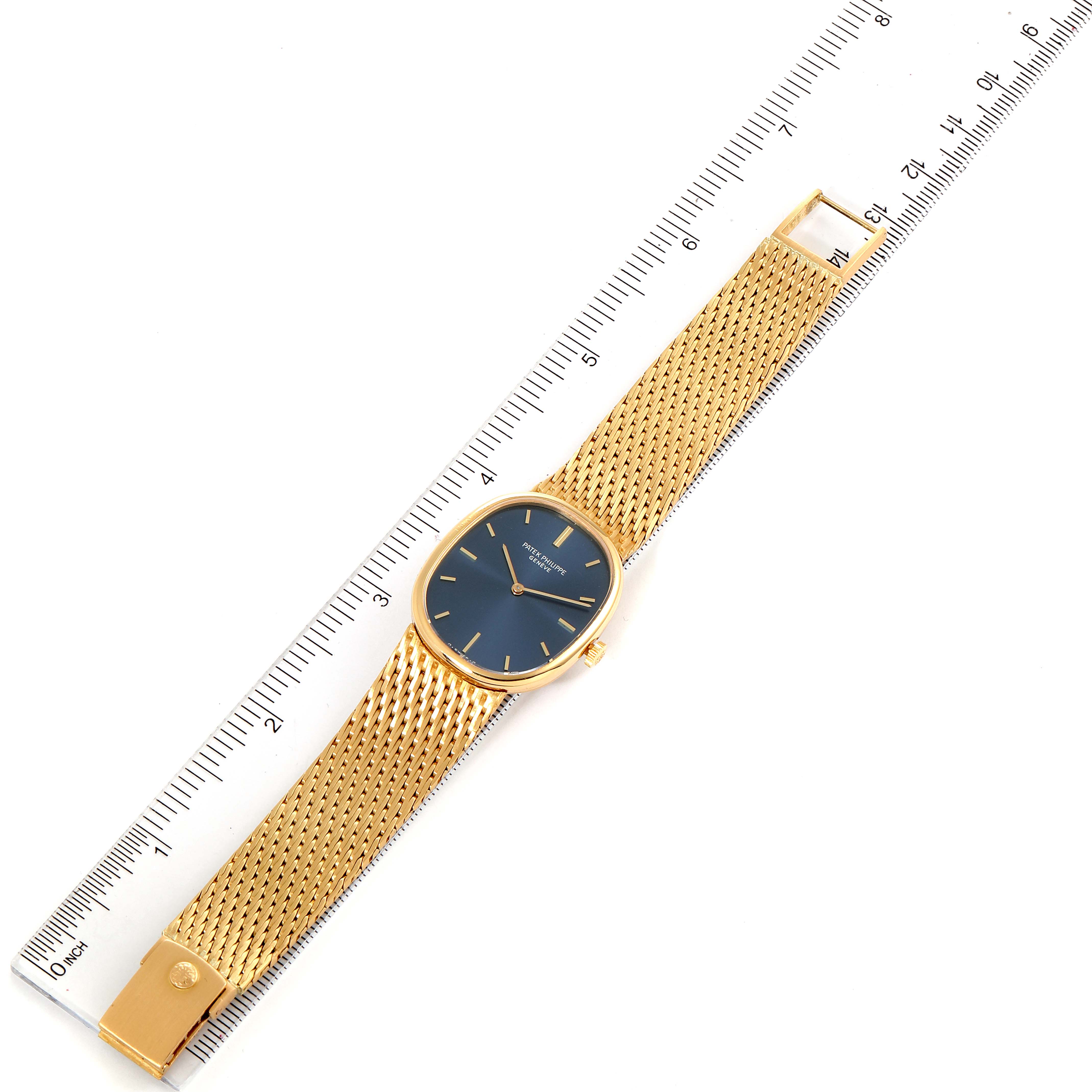 The image shows the front view of a Patek Philippe Golden Ellipse 3548 Women
s Yellow Gold Blue Dial 3548 Women
s Yellow Gold Blue Dial model watch with a ruler, displaying the watch face and bracelet.