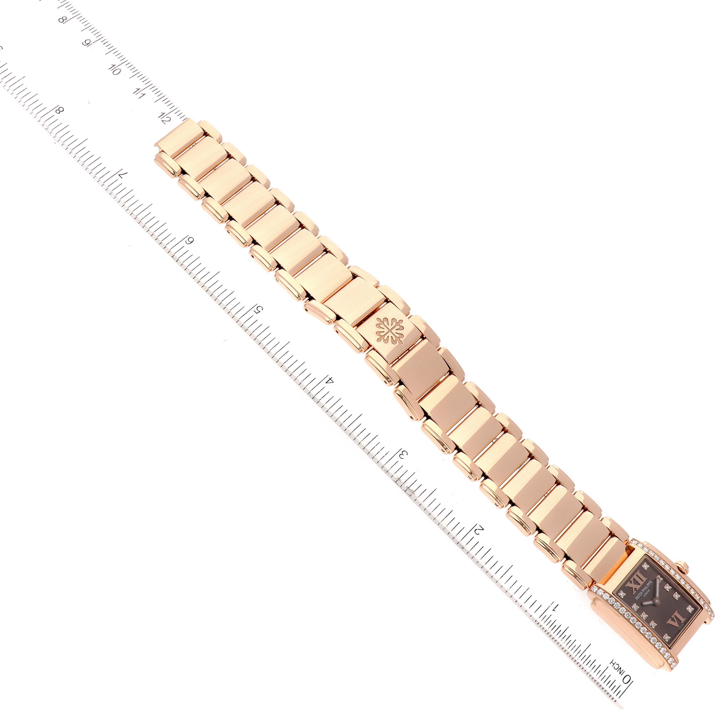 The image shows the Patek Philippe Twenty-4 4908/11R-010 Women's Rose Gold Brown Dial 4908/11R-010 Women's Rose Gold Brown Dial watch laid flat alongside a ruler, highlighting its bracelet and rectangular dial.