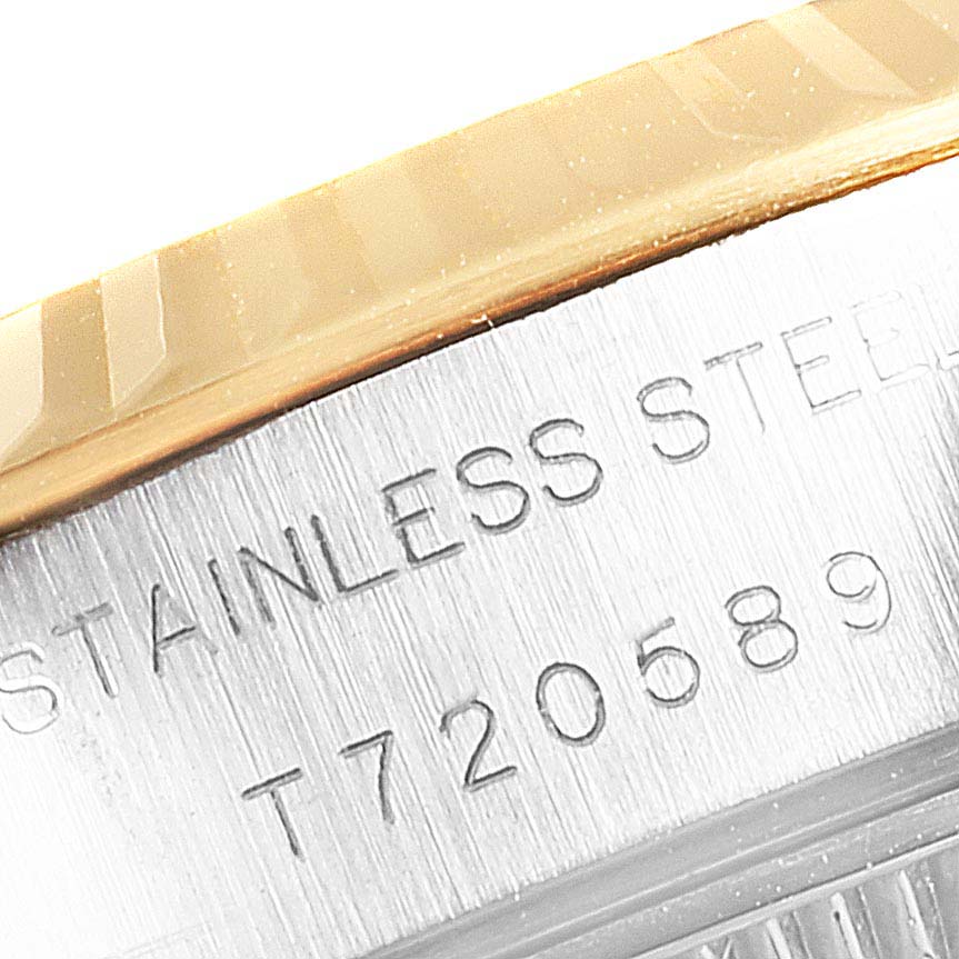 This is a close-up image of the side of a Rolex Datejust 69173 Women
s Steel and Gold (two tone) Champagne Dial 69173 Women
s Steel and Gold (two tone) Champagne Dial watch, showing the bezel and case with engraved serial number.
