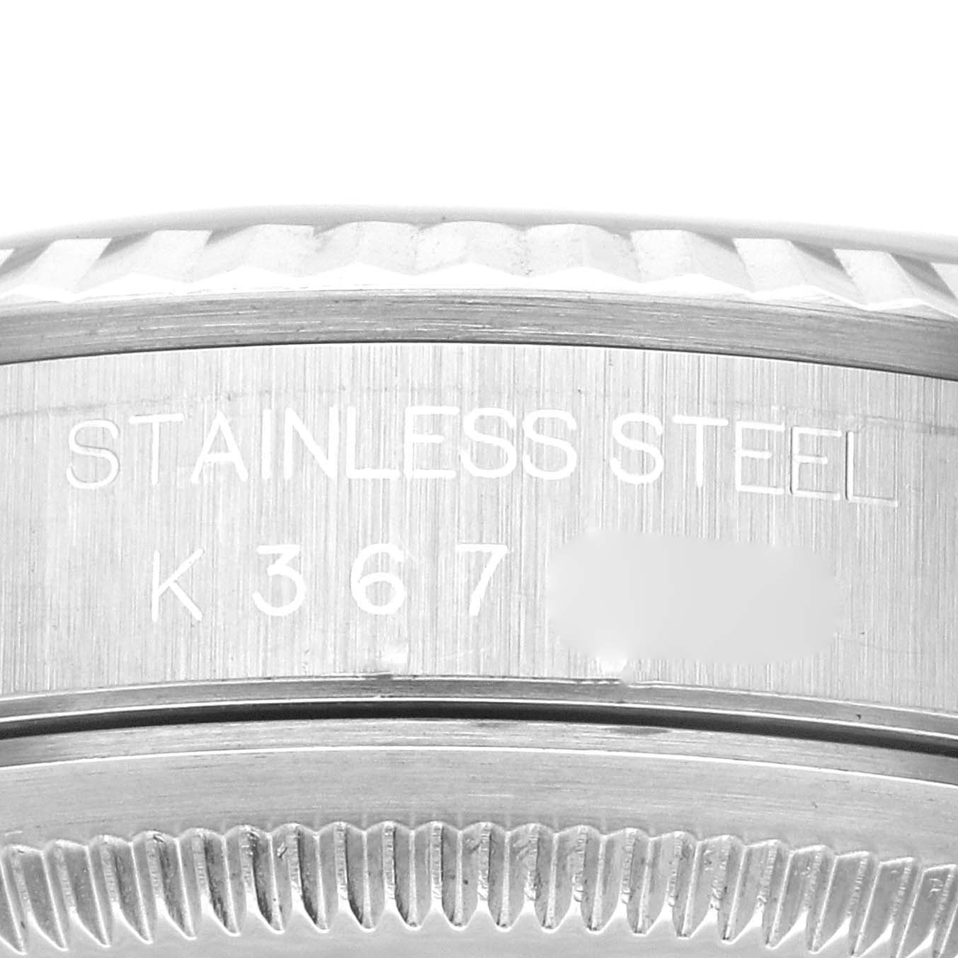 The image shows a close-up of the side of a Rolex Datejust 16234 Men's Stainless Steel Black Dial 16234 Men's Stainless Steel Black Dial watch case, focusing on the inscription and serial number on its stainless steel surface.