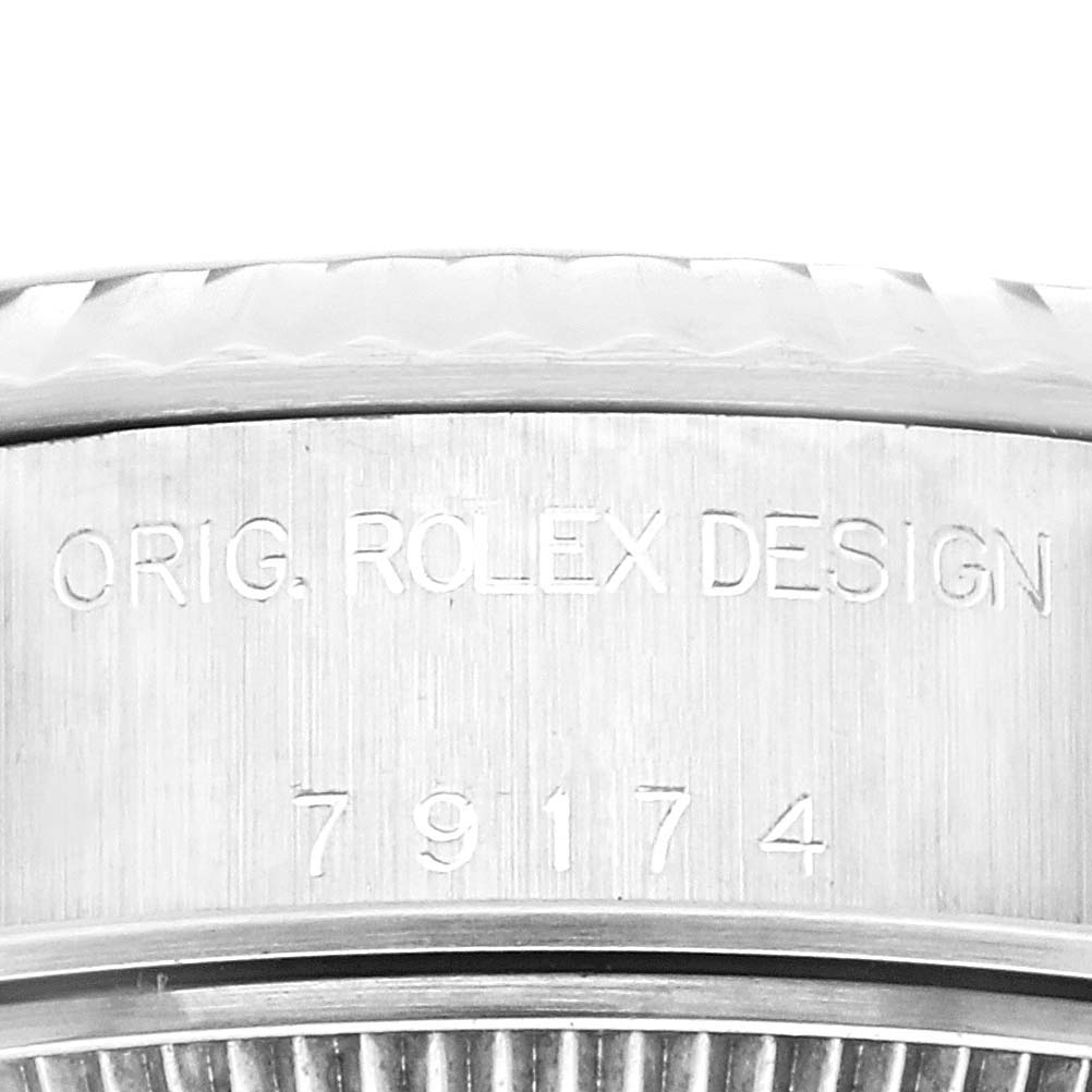 The image shows a close-up of the case side of a Rolex Datejust 79174 Women's Stainless Steel Blue Dial 79174 Women's Stainless Steel Blue Dial watch, displaying the engraved words "ORIG. ROLEX DESIGN" and model number 79174.