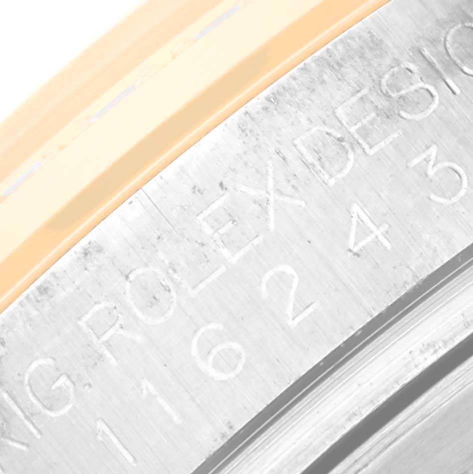 This is a close-up angle showing the engraved text and edge of the bezel of a Rolex Datejust 116243 Men's Steel and Gold (two tone) Champagne Dial 116243 Men's Steel and Gold (two tone) Champagne Dial watch.