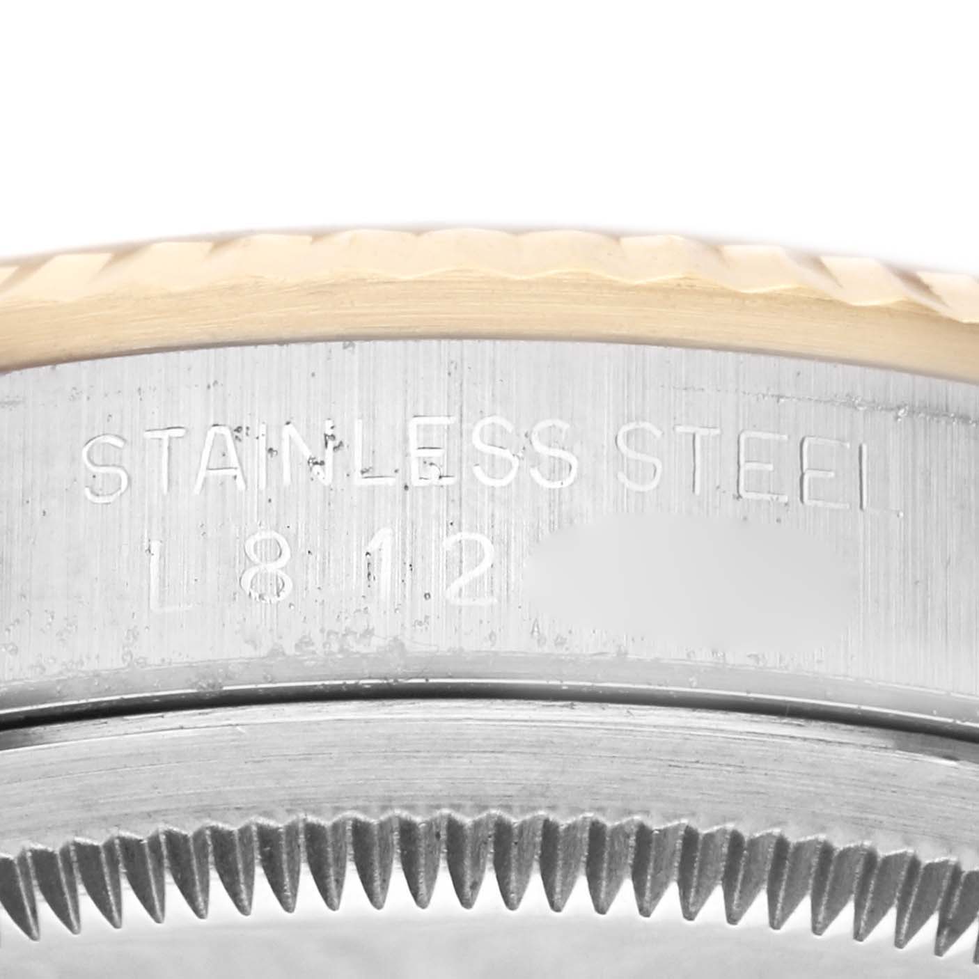 The image shows a close-up of the side engraving and fluted bezel of a Rolex Datejust 16233 Men's Steel and Gold (two tone) Champagne Dial 16233 Men's Steel and Gold (two tone) Champagne Dial watch.