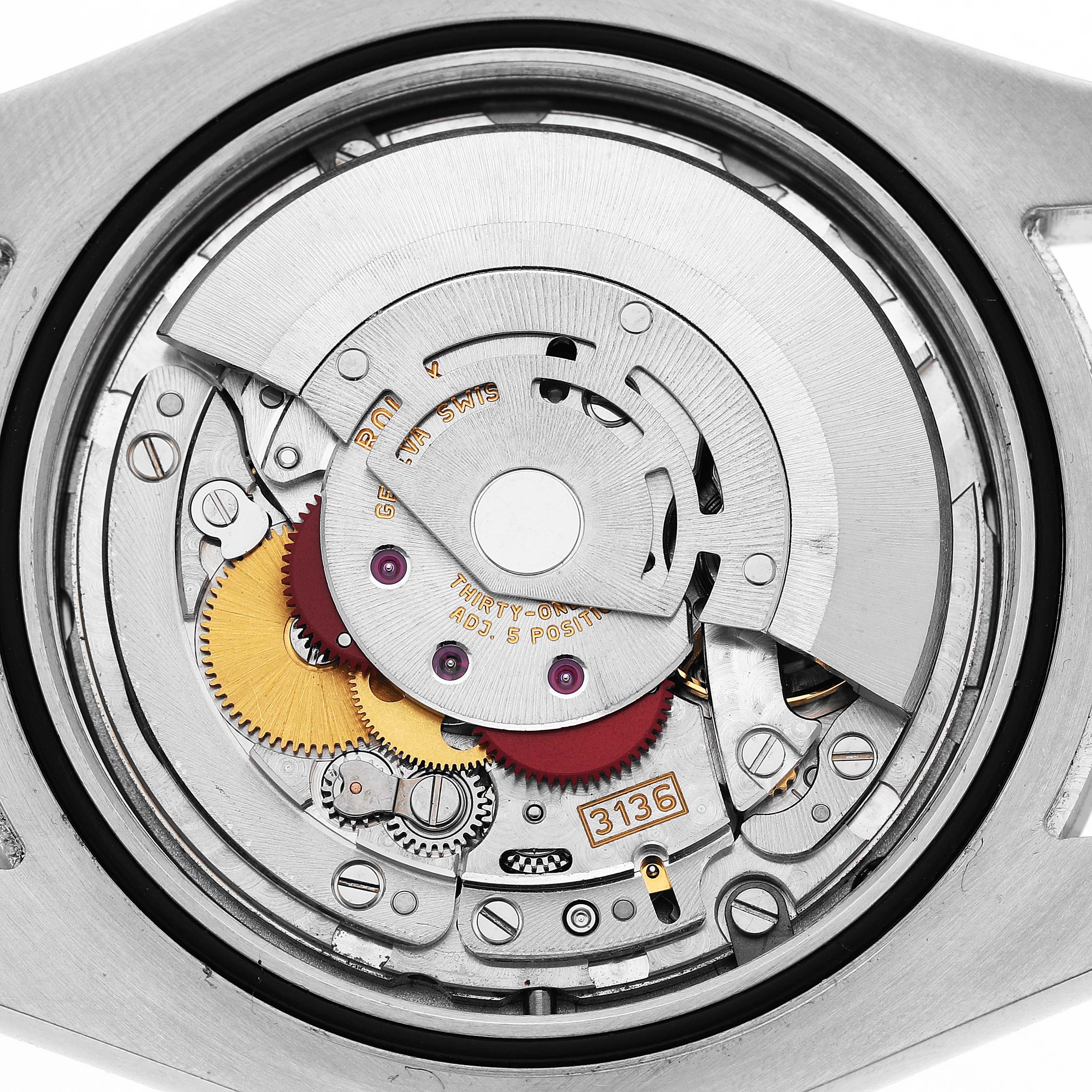 The image shows the intricate internal mechanism of a Rolex Datejust 41 116300 Men's Stainless Steel Blue Dial, viewed from the back with various gears and components visible.