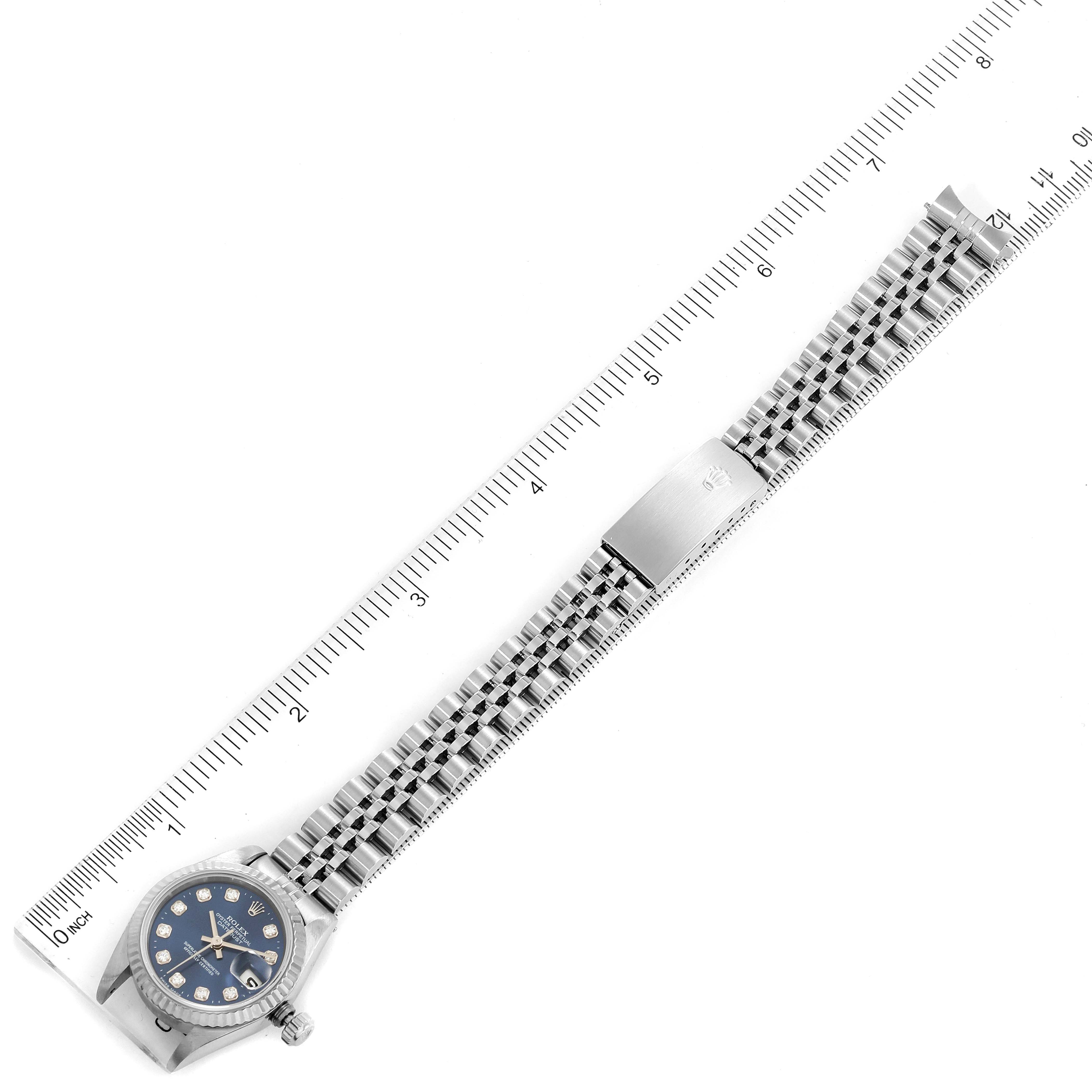 The image shows a Rolex Datejust 69174 Women
s Stainless Steel Blue Dial 69174 Women
s Stainless Steel Blue Dial watch lying flat, displaying the face and bracelet, with rulers for scale.