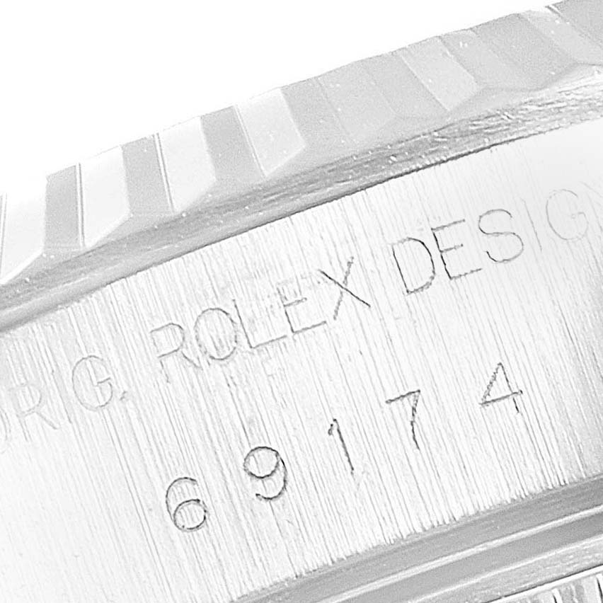 This image shows a close-up of the Rolex Datejust 69174 Women
s Stainless Steel Blue Dial 69174 Women
s Stainless Steel Blue Dial model
s engraved side, including the serial number and part of the fluted bezel.