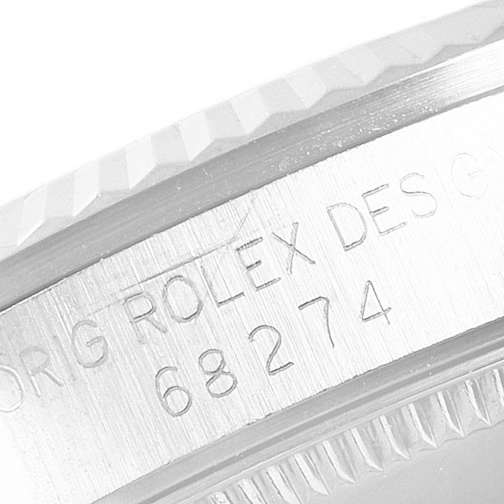 The image shows a close-up of the engraved model number and part of the bezel of a Mid-Size Rolex watch.