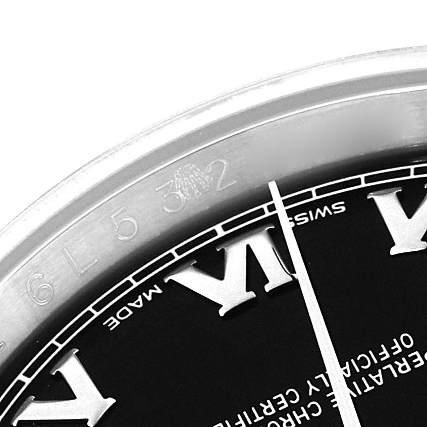 This image shows a close-up of the bezel and part of the dial of a Rolex Datejust 116234 Men's Stainless Steel Black Dial 116234 Men's Stainless Steel Black Dial watch, focusing on Roman numerals and text.