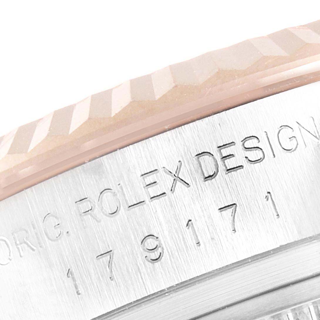 This image shows a close-up of the bezel and part of the case side of a Rolex Datejust 179171 Women
s Steel and Gold (two tone) White Dial 179171 Women
s Steel and Gold (two tone) White Dial watch with engraved text.