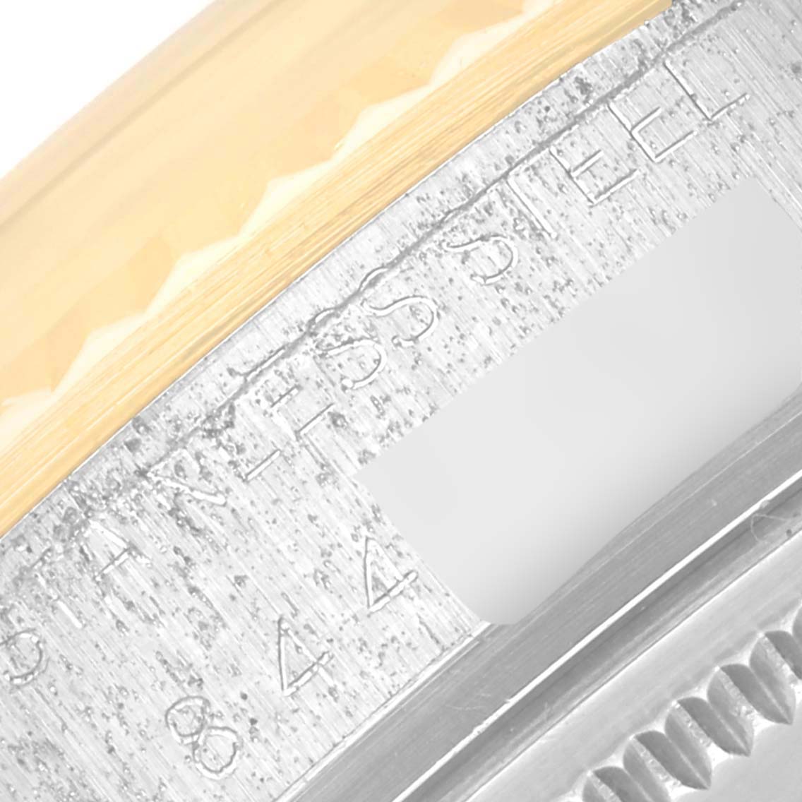 The image shows a close-up of the engraved case side and fluted bezel of the Vintage Collection model by Rolex.