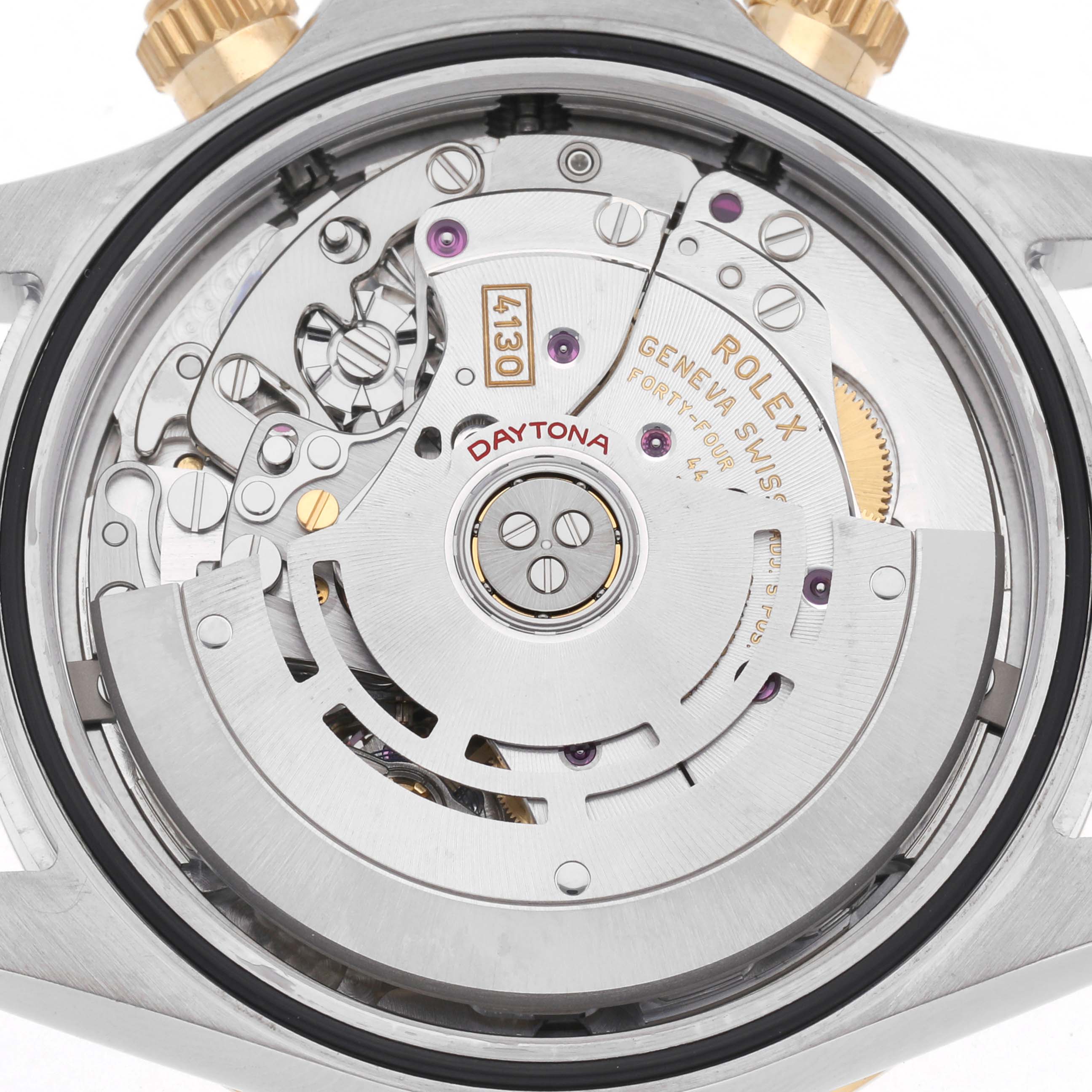 The image shows the movement of a Rolex Daytona 116503 Men
s Steel and Gold (two tone) White Dial 116503 Men
s Steel and Gold (two tone) White Dial watch from the back, featuring intricate gears and engraving details.