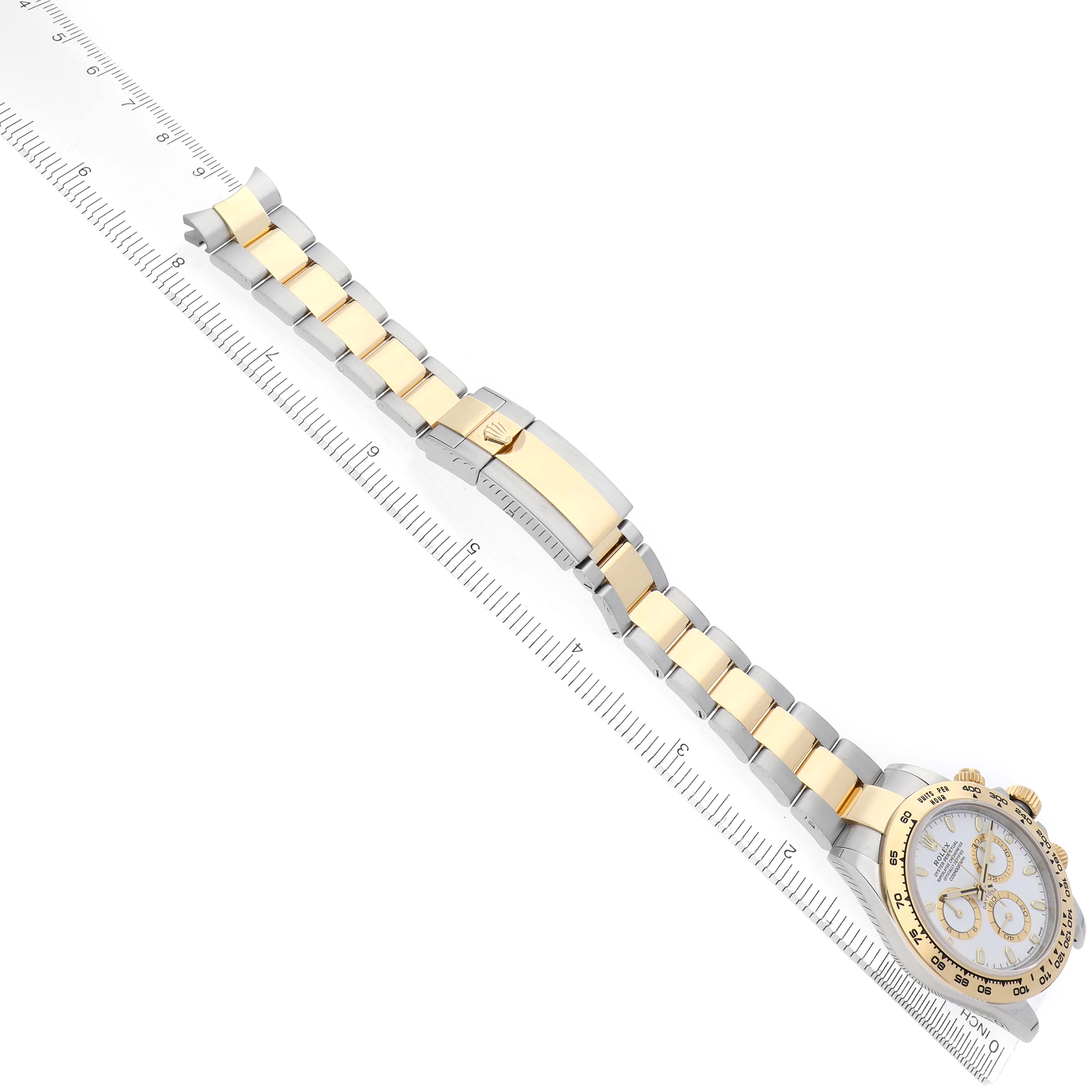 The Rolex Daytona 116503 Men
s Steel and Gold (two tone) White Dial 116503 Men
s Steel and Gold (two tone) White Dial watch is shown from an overhead angle, highlighting its bracelet and clasp alongside a ruler for scale.