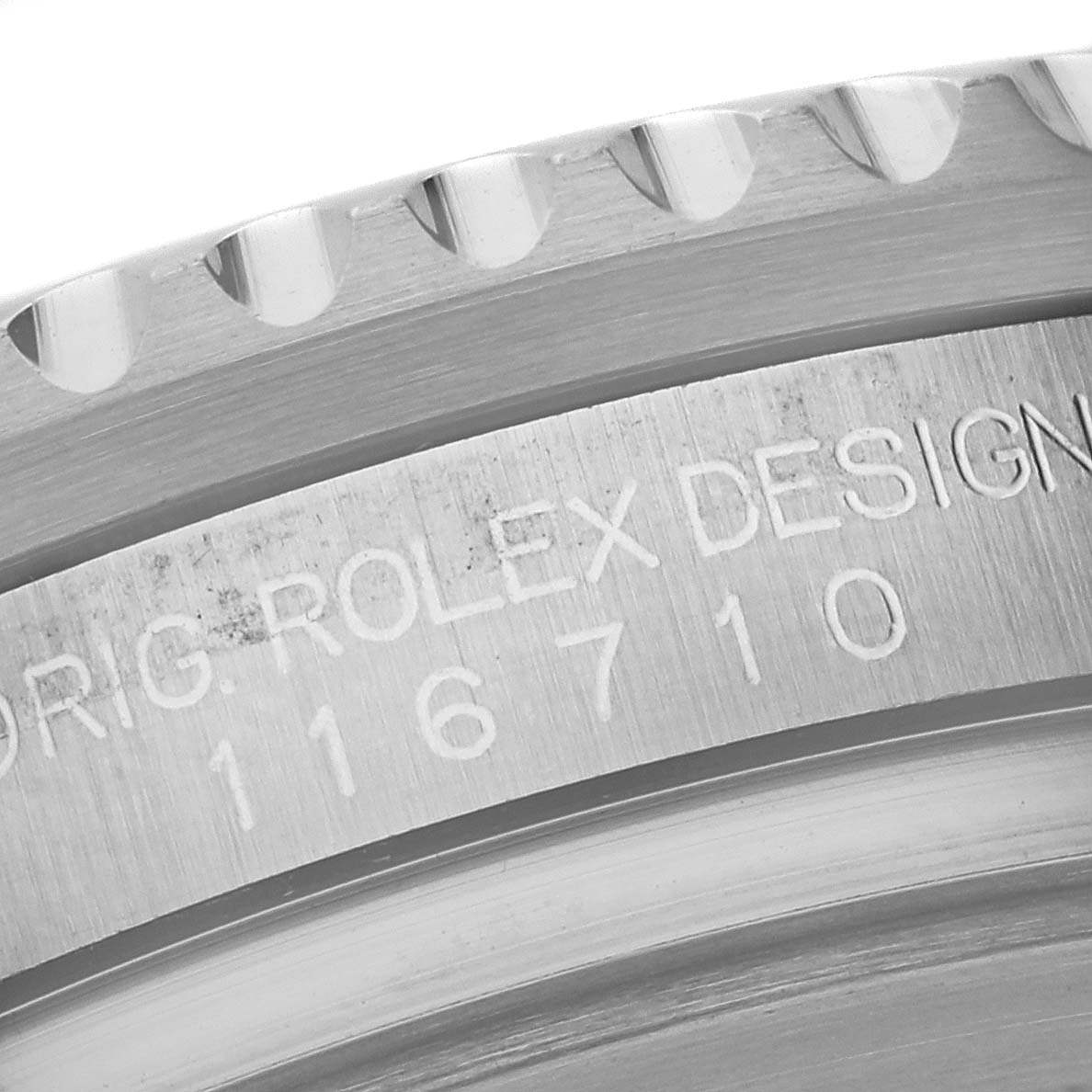 The image shows a close-up of the bezel and engraved serial number on a Rolex GMT-Master 116710 Men's Stainless Steel Black Dial 116710 Men's Stainless Steel Black Dial watch.