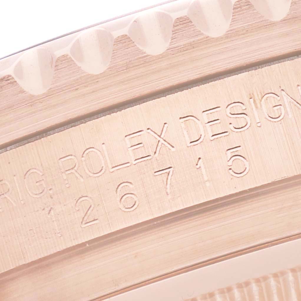 The image shows an engraving on the side of the Rolex GMT-Master 126715CHNR Men
s Rose Gold Black Dial 126715CHNR Men
s Rose Gold Black Dial model
s case with part of the bezel
s edge.