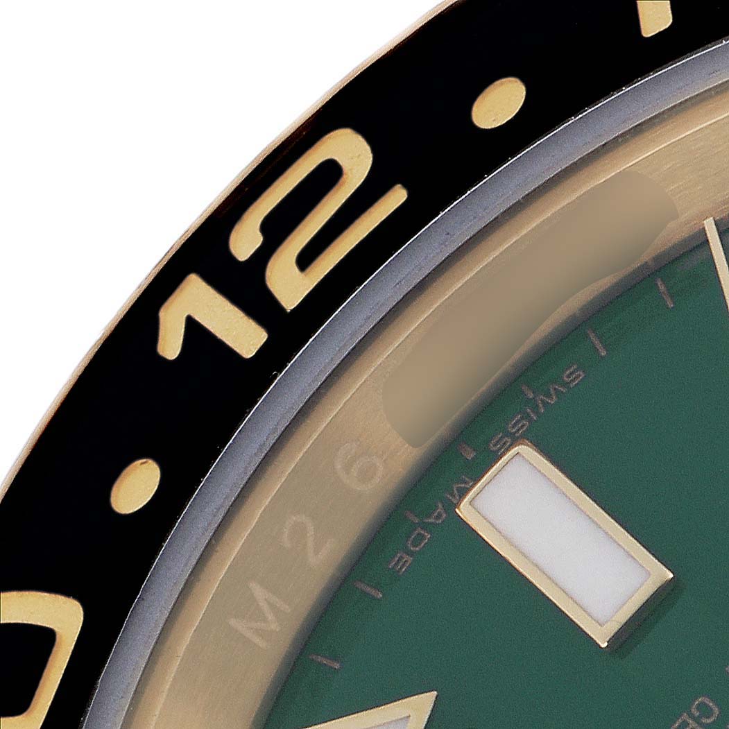 The image shows a close-up of the Rolex GMT-Master 116718 Men
s Yellow Gold Green Dial 116718 Men
s Yellow Gold Green Dial watch bezel and partial dial from a side angle.