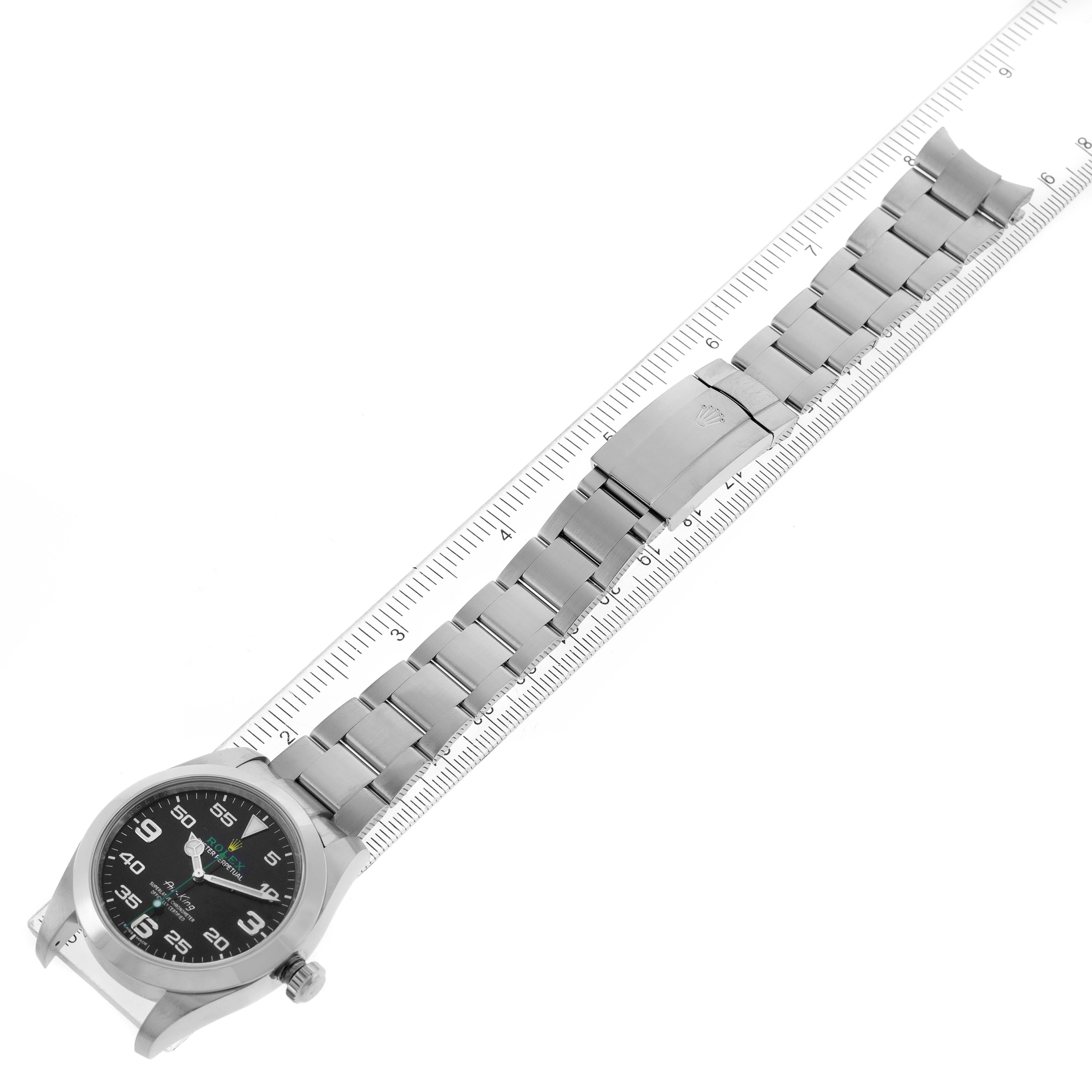 The image shows the full length of a Rolex Air-King 116900 Men's Stainless Steel Black Dial 116900 Men's Stainless Steel Black Dial watch and its metal bracelet laid alongside a ruler.