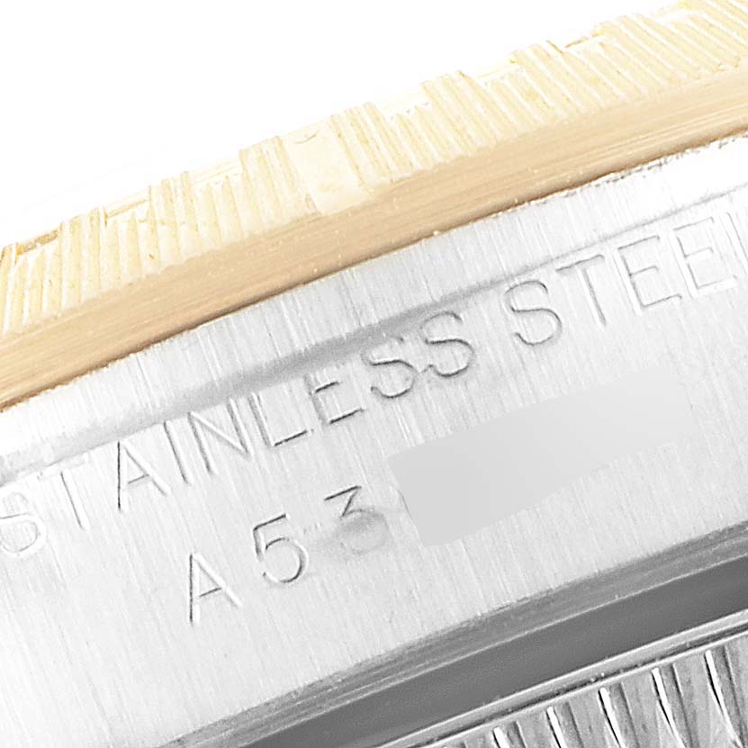 The image shows a close-up of the bezel and case with engraving details on a Rolex Oyster Perpetual 76243 Women
s Steel and Gold (two tone) Champagne Dial 76243 Women
s Steel and Gold (two tone) Champagne Dial watch.