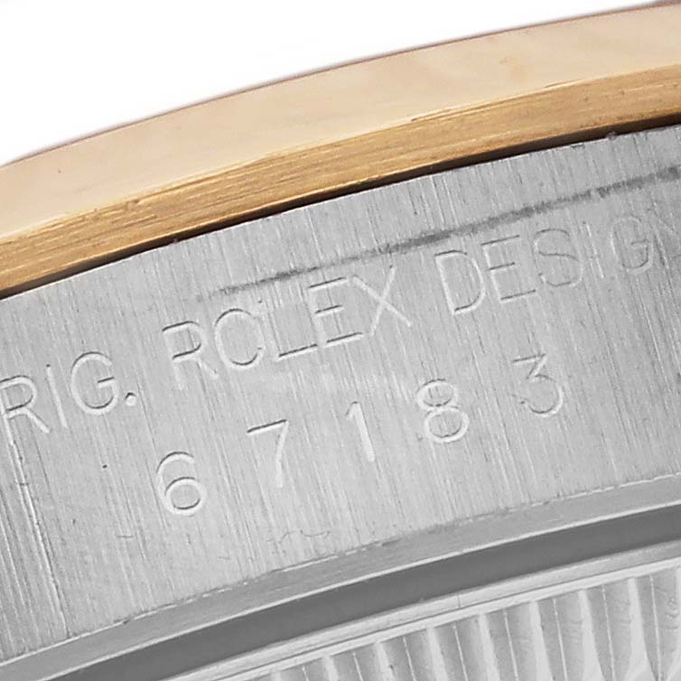 This image shows a close-up view of the bezel and case with the engraved serial number of a Rolex Oyster Perpetual 67183 Women's Steel and Gold (two tone) Grey Dial 67183 Women's Steel and Gold (two tone) Grey Dial watch.