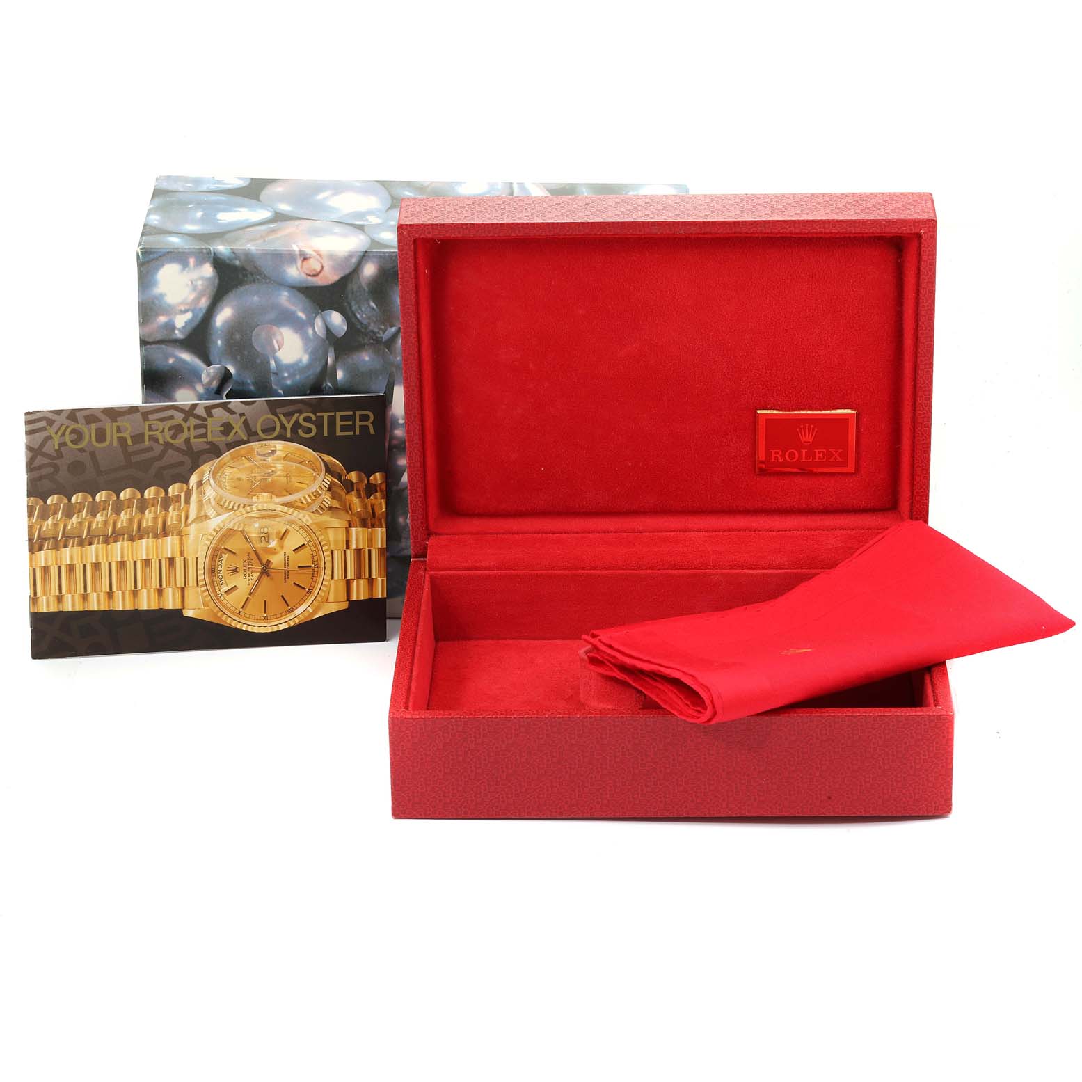 The image shows the Rolex President 69038 Women's Yellow Gold Black Dial 69038 Women's Yellow Gold Black Dial model watch's red case, a red cloth, and an information booklet.