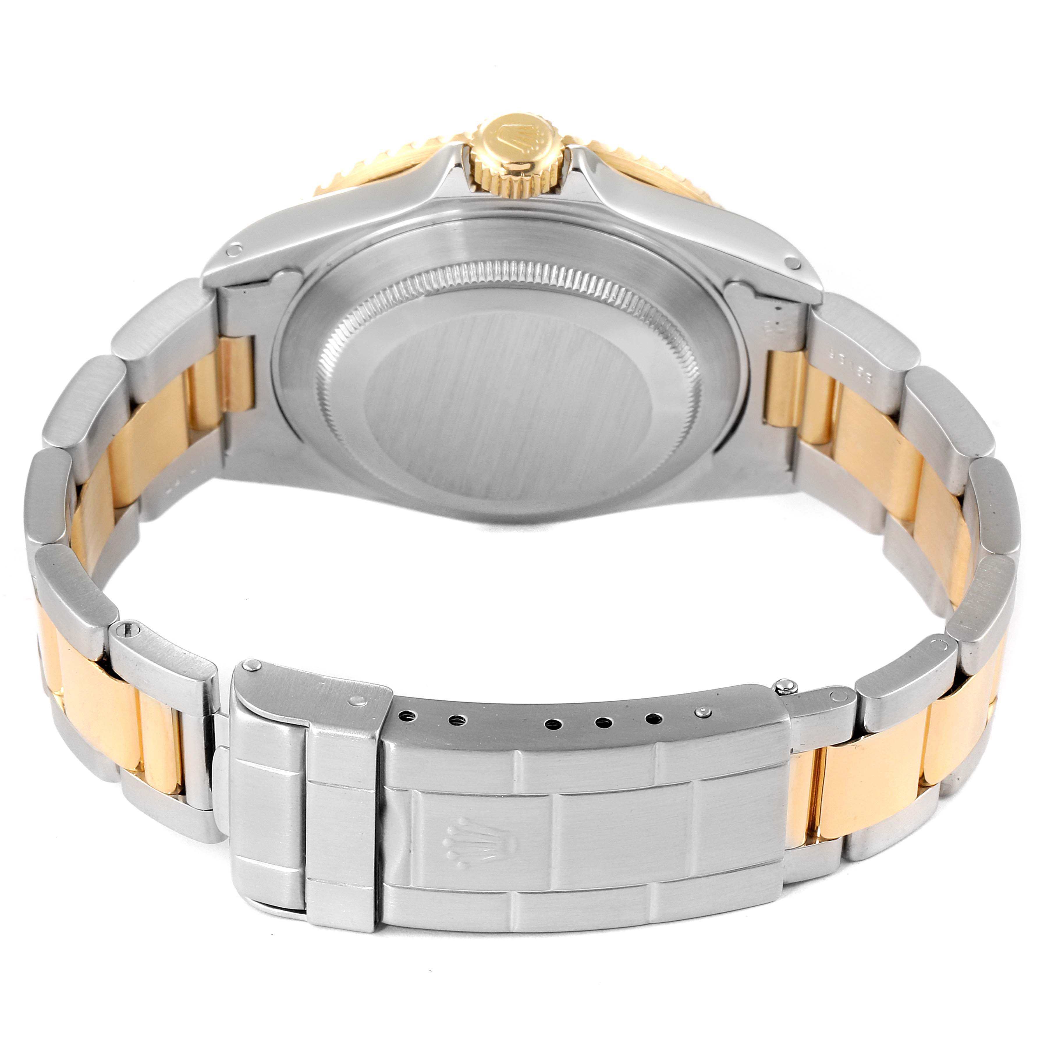 The image shows the back of a Rolex Submariner 16613 Men's Steel and Gold (two tone) Black Dial 16613 Men's Steel and Gold (two tone) Black Dial, highlighting its case back, bracelet, and clasp in a stainless steel and gold two-tone finish.