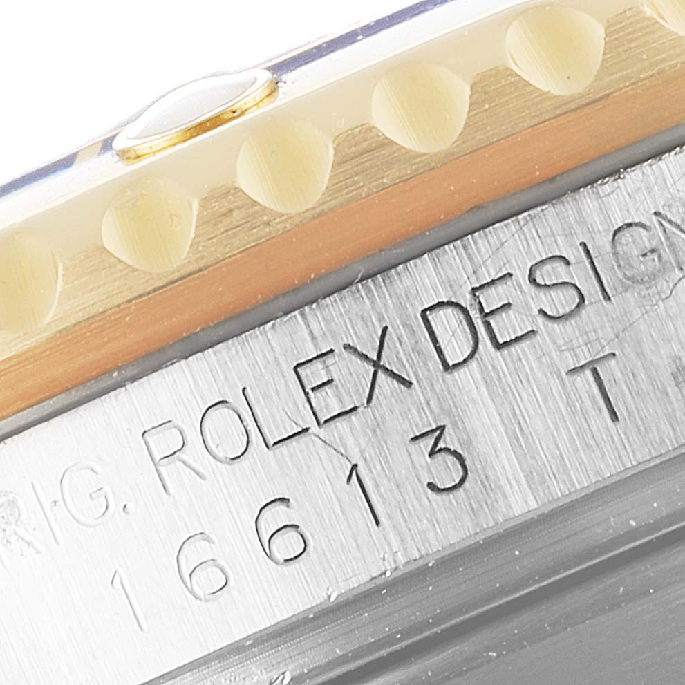 The image shows a close-up of the model and serial number engraving on the side of a Rolex Submariner 16613 Men
s Steel and Gold (two tone) Blue Dial 16613 Men
s Steel and Gold (two tone) Blue Dial watch case.