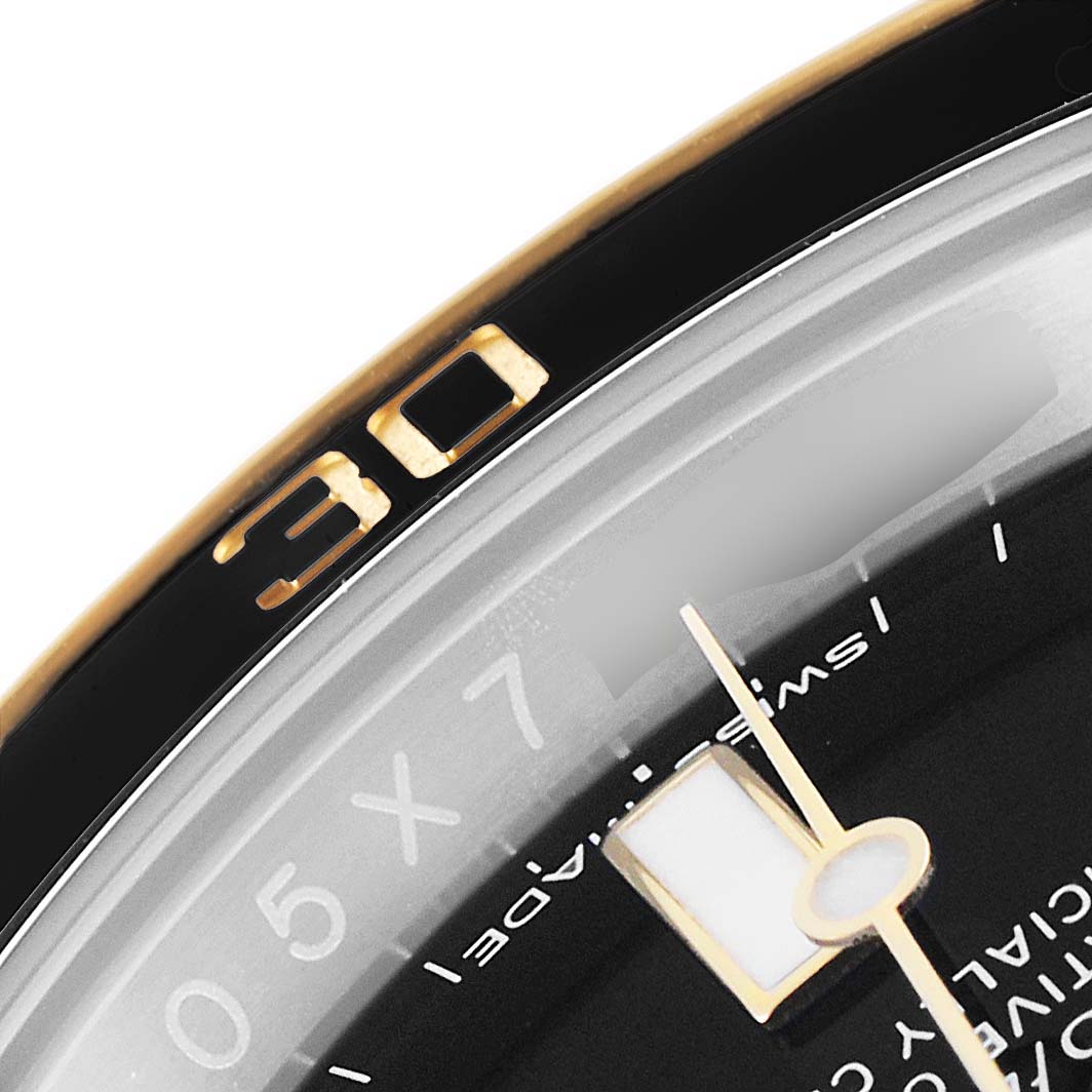The image shows a close-up of the bezel and part of the dial of a Rolex Submariner 116613 Men
s Steel and Gold (two tone) Black Dial 116613 Men
s Steel and Gold (two tone) Black Dial watch.