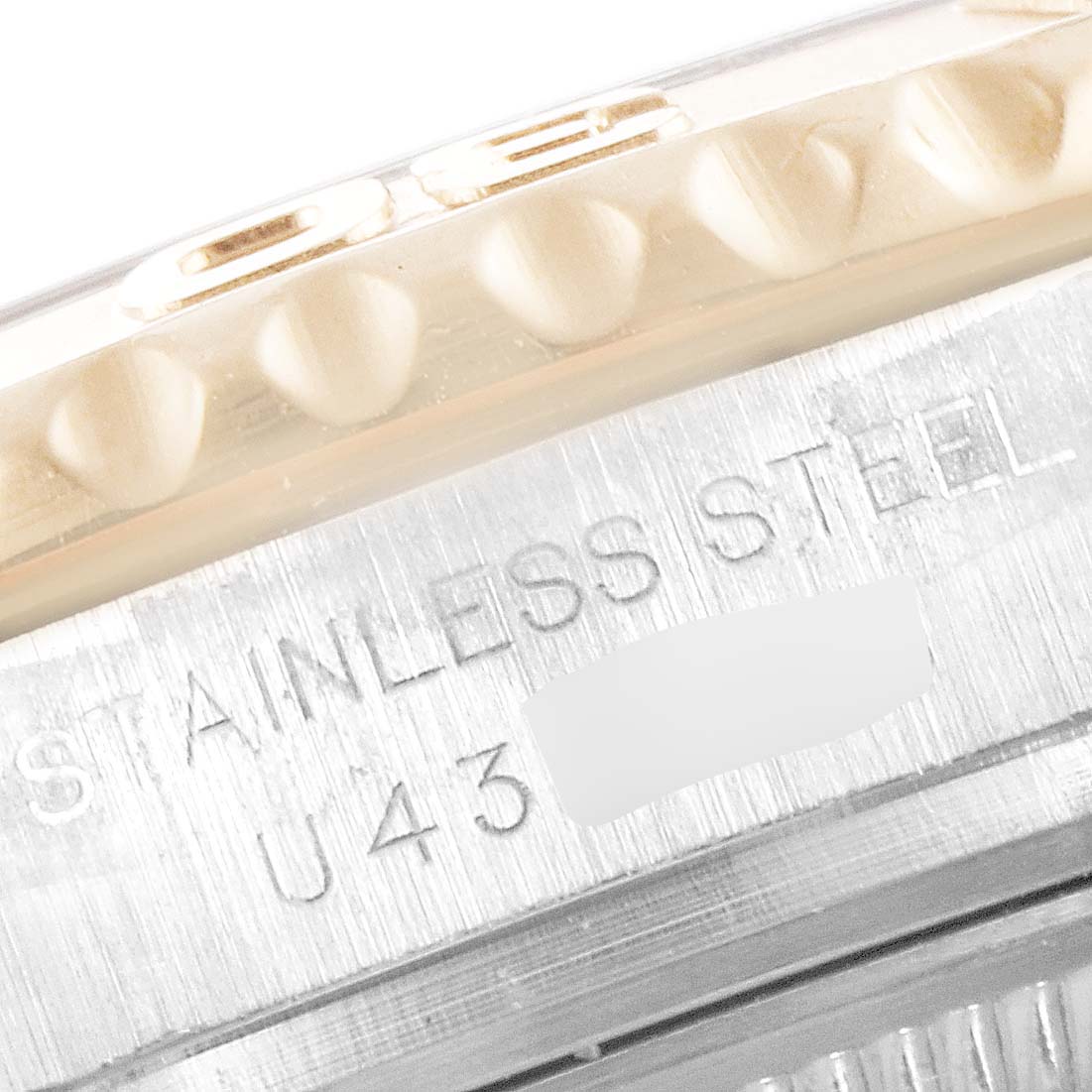 The image shows a close-up of the Yacht-Master model by Rolex, focusing on the stainless steel bezel and case with engraved text.