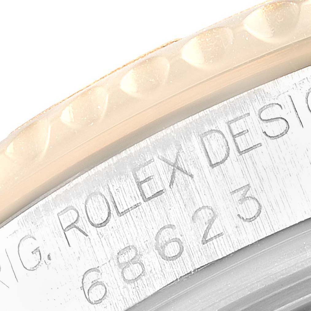 The image shows a close-up of the engraved side of the bezel and case of a Rolex Yacht-Master 69623 Women's Steel and Gold (two tone) Grey Dial 69623 Women's Steel and Gold (two tone) Grey Dial watch.