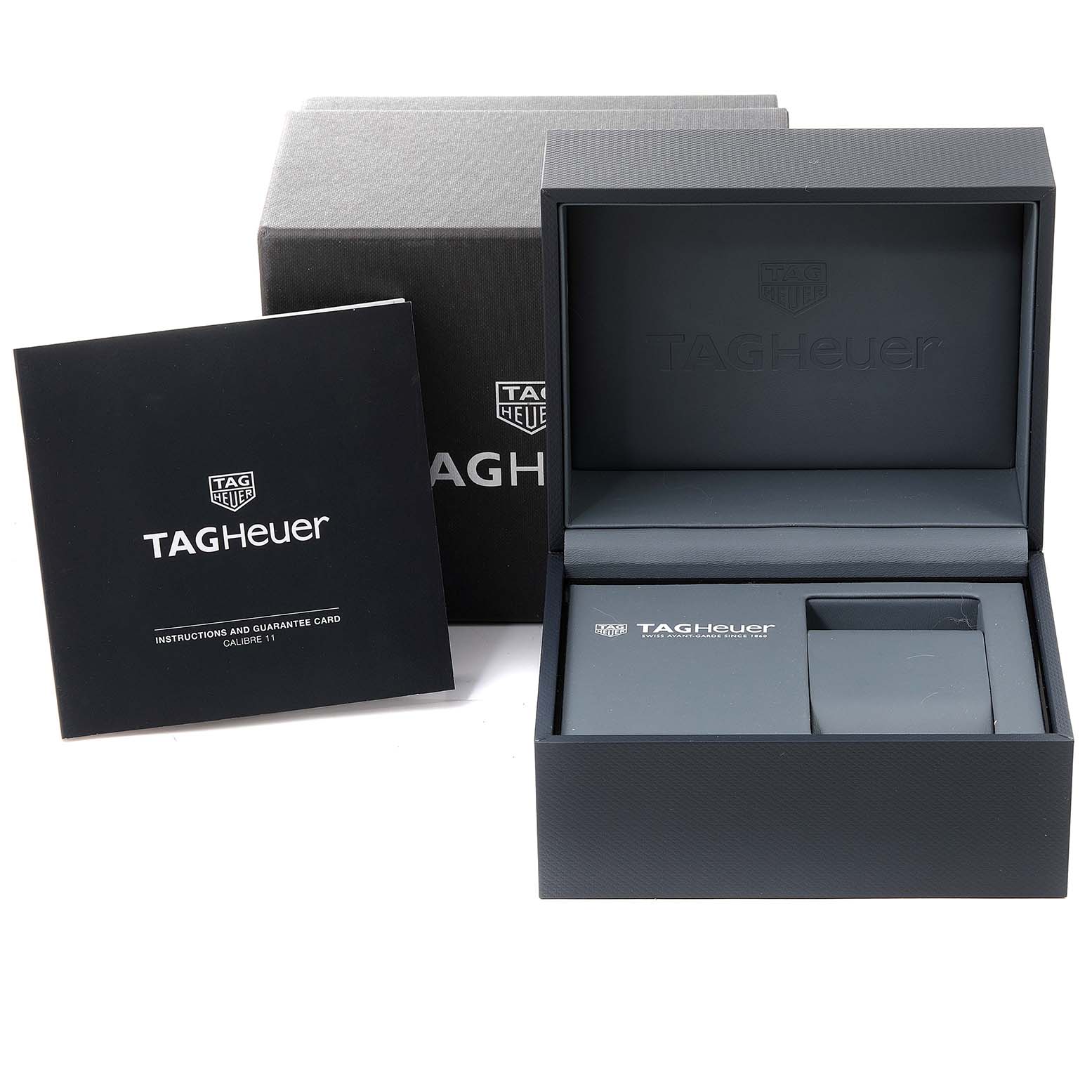 The image shows the packaging and instruction manual for the Monaco model by Tag Heuer, including the box, booklet, and guarantee card.
