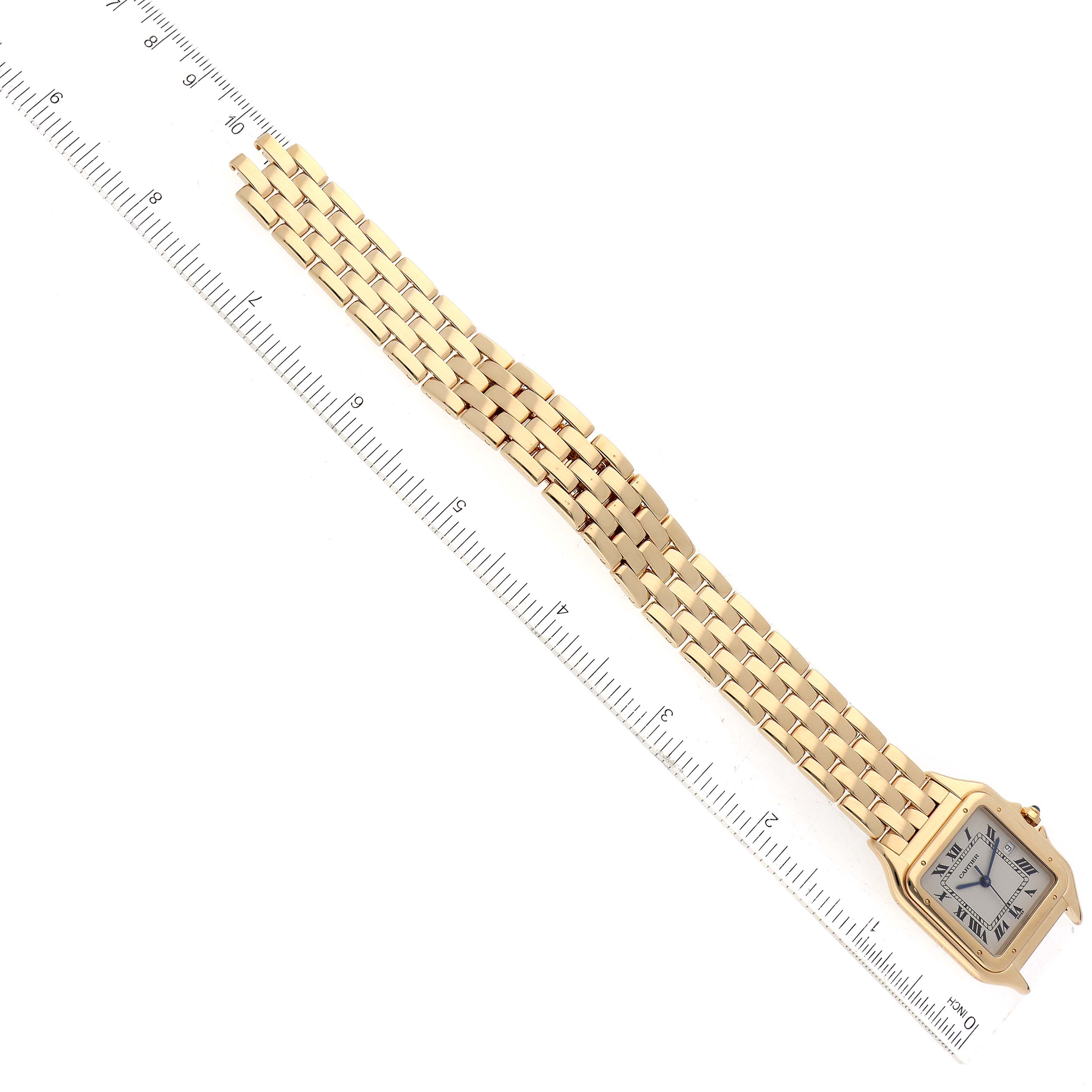 The image shows a Panthere model Cartier watch laid flat with its bracelet extended next to a ruler.
