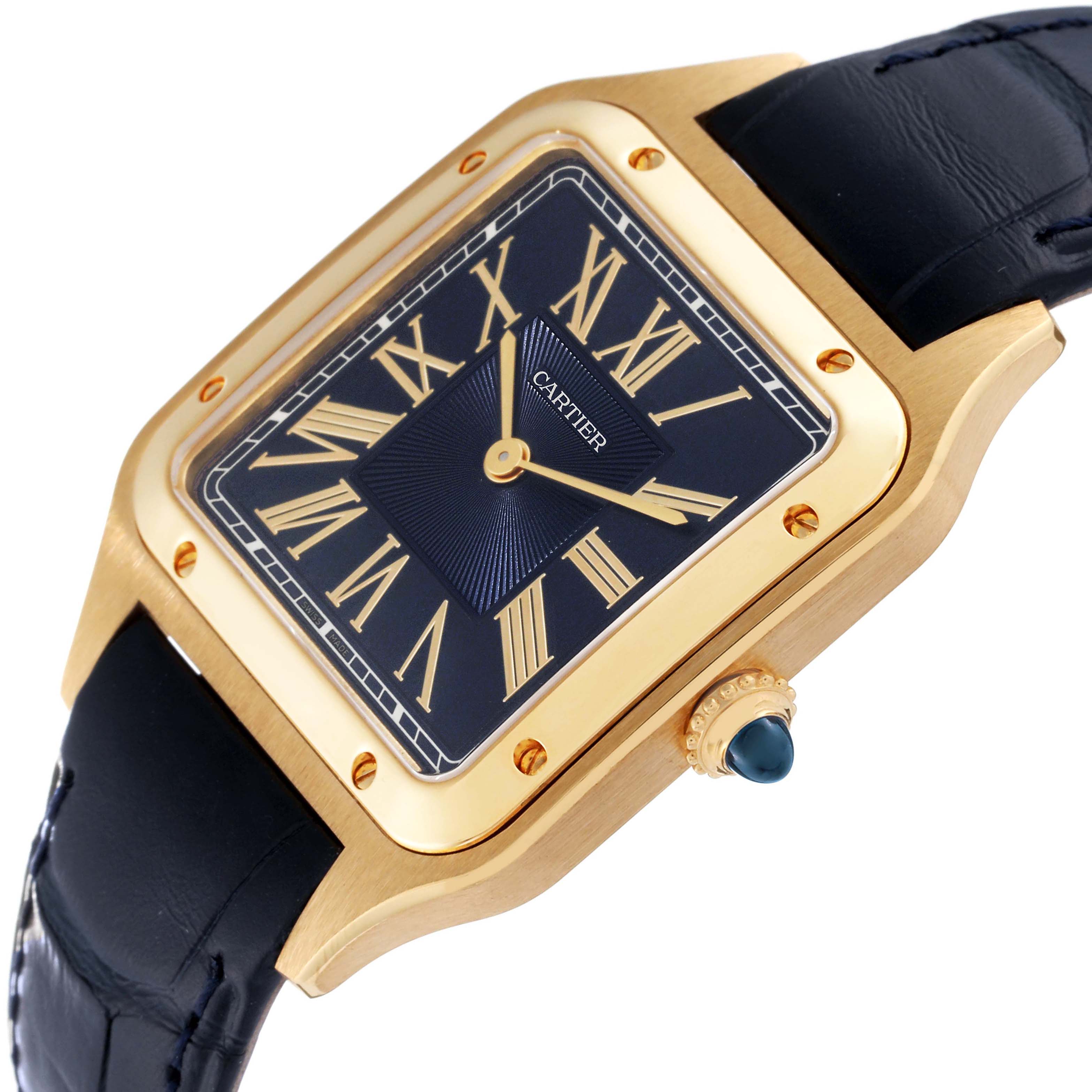 The image shows a Cartier Santos Dumont WGSA0077 Men
s Yellow Gold Blue Dial WGSA0077 Men
s Yellow Gold Blue Dial watch at an angle highlighting its face, bezel, crown, and leather strap.