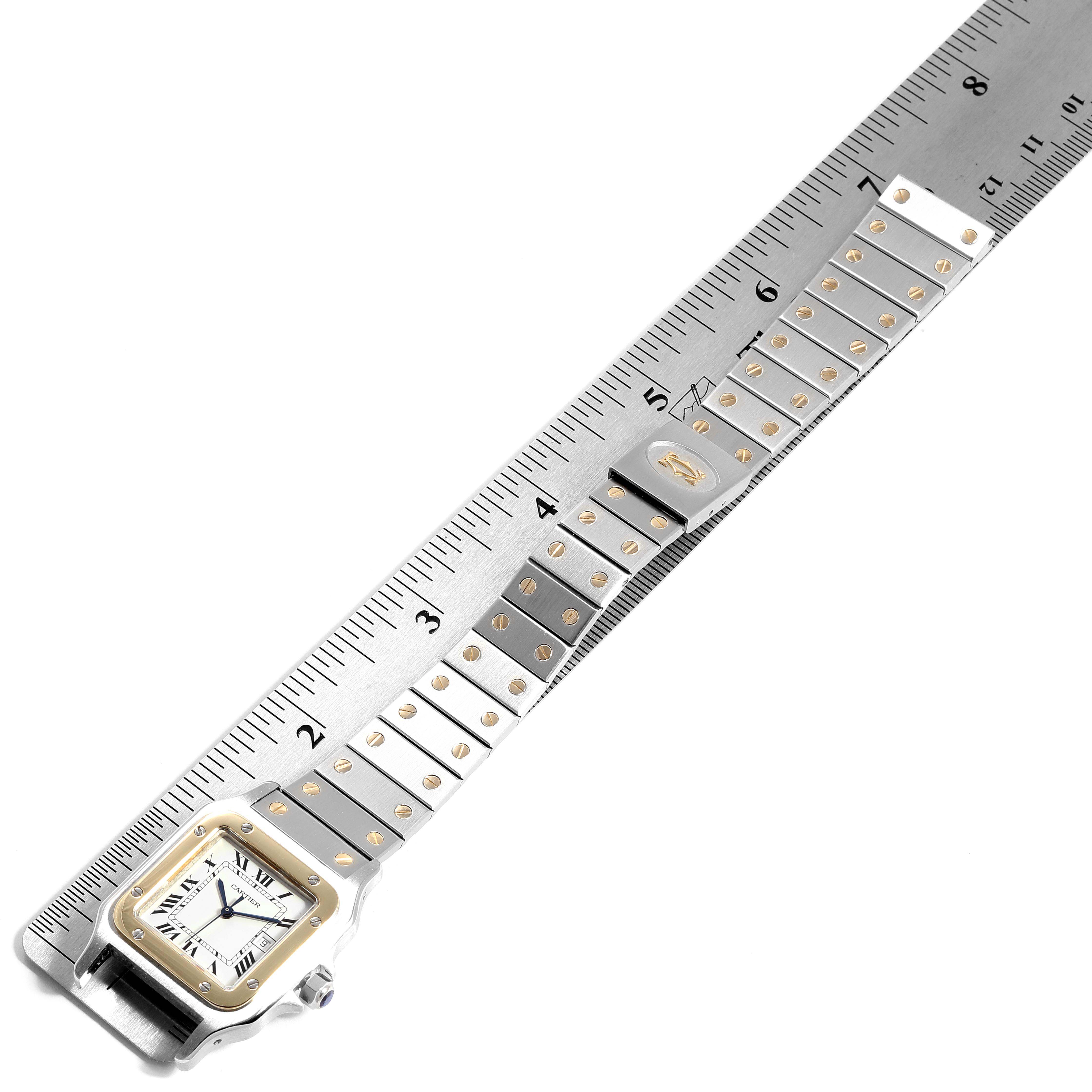 This image shows the Cartier Santos 2380 Men's Steel and Gold (two tone) White Dial 2380 Men's Steel and Gold (two tone) White Dial watch from a top-down angle, highlighting the face, bezel, and band against a ruler.