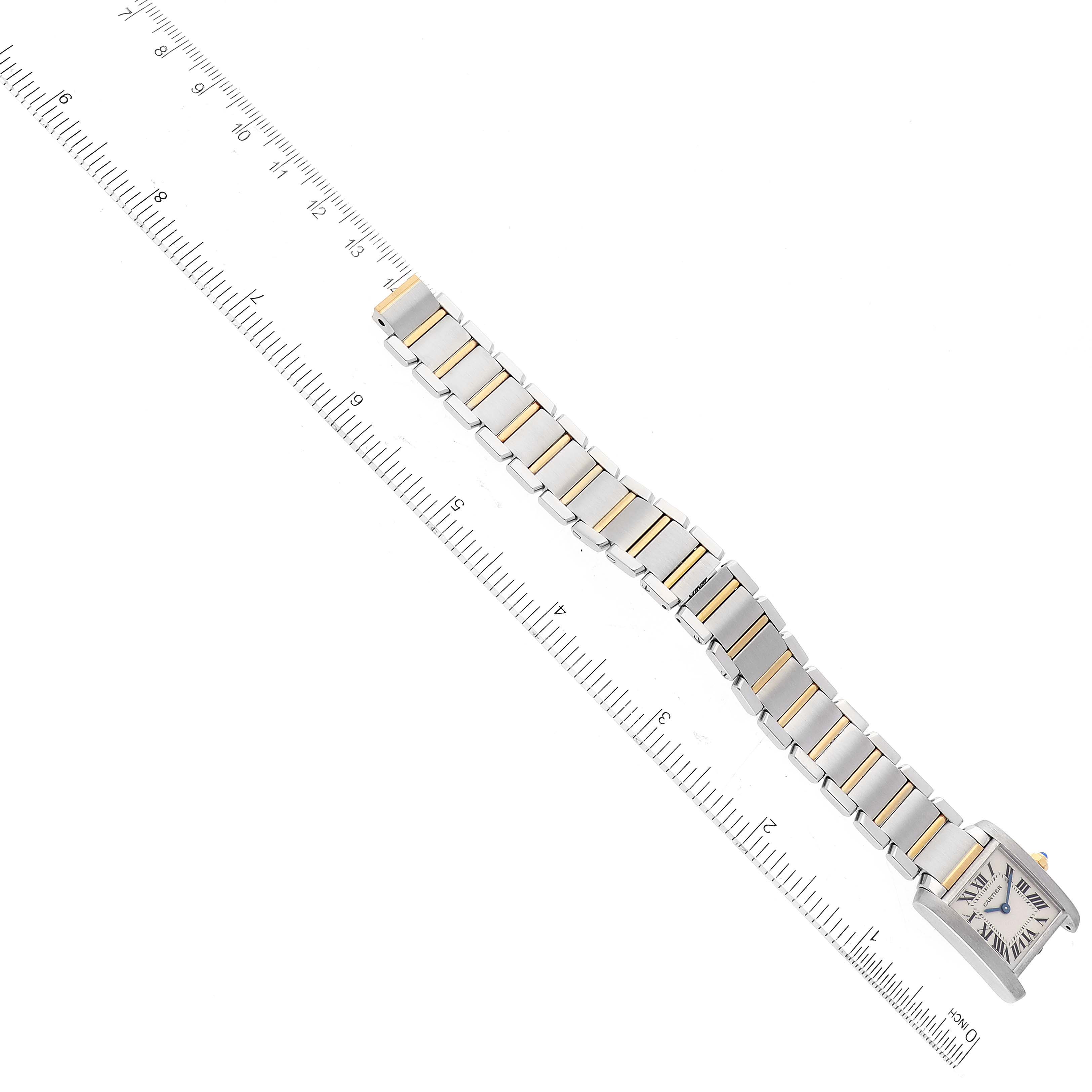 The image shows a Cartier Tank Francaise W51007Q4 Women
s Steel and Gold (two tone) Silver Dial W51007Q4 Women
s Steel and Gold (two tone) Silver Dial watch laid flat with its bracelet extended next to a ruler for scale.