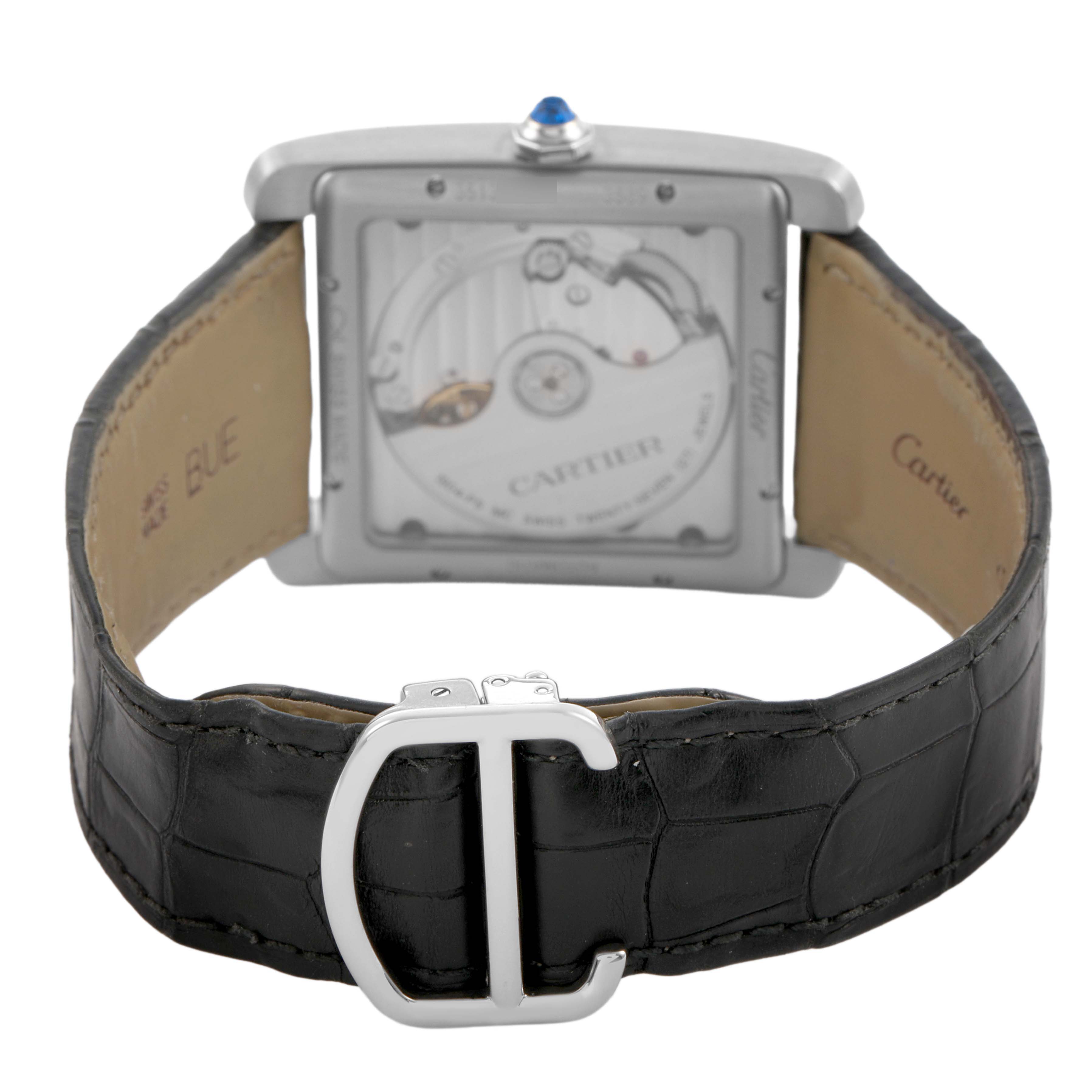 The Cartier Tank MC W5330003 Men's Stainless Steel Silver Dial watch is shown from the back, displaying its movement and black leather strap with a clasp.