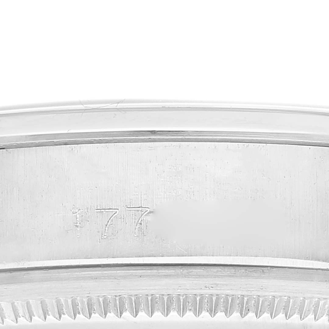 This image shows a close-up of the case edge and part of the bezel of a Rolex Vintage Collection 1500 Men's Stainless Steel Silver Dial 1500 Men's Stainless Steel Silver Dial watch, highlighting some engraved markings.