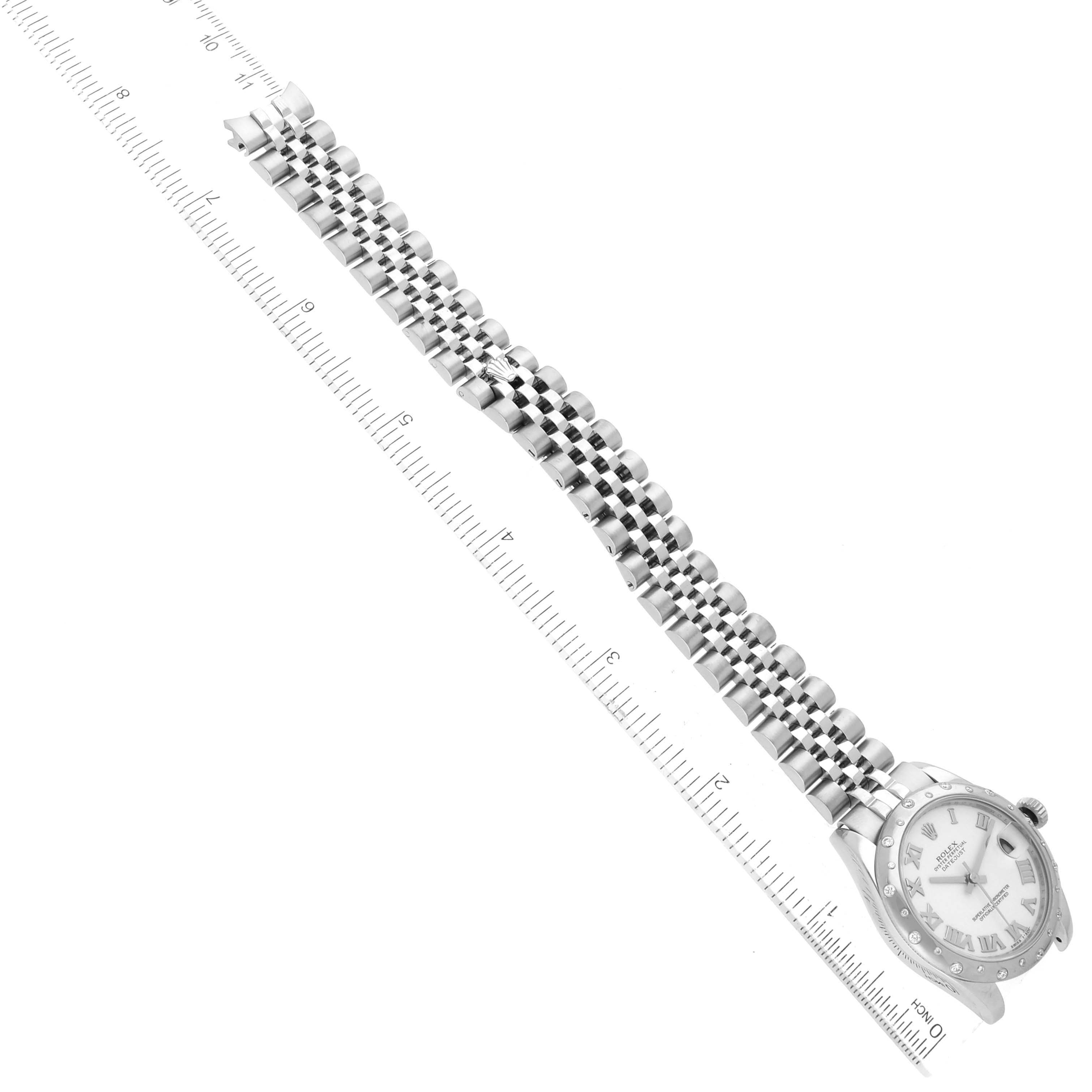The image shows a top-down view of a Rolex Datejust 178344 Women's Stainless Steel White Dial 178344 Women's Stainless Steel White Dial watch displaying the face, band, and clasp alongside a measuring scale.