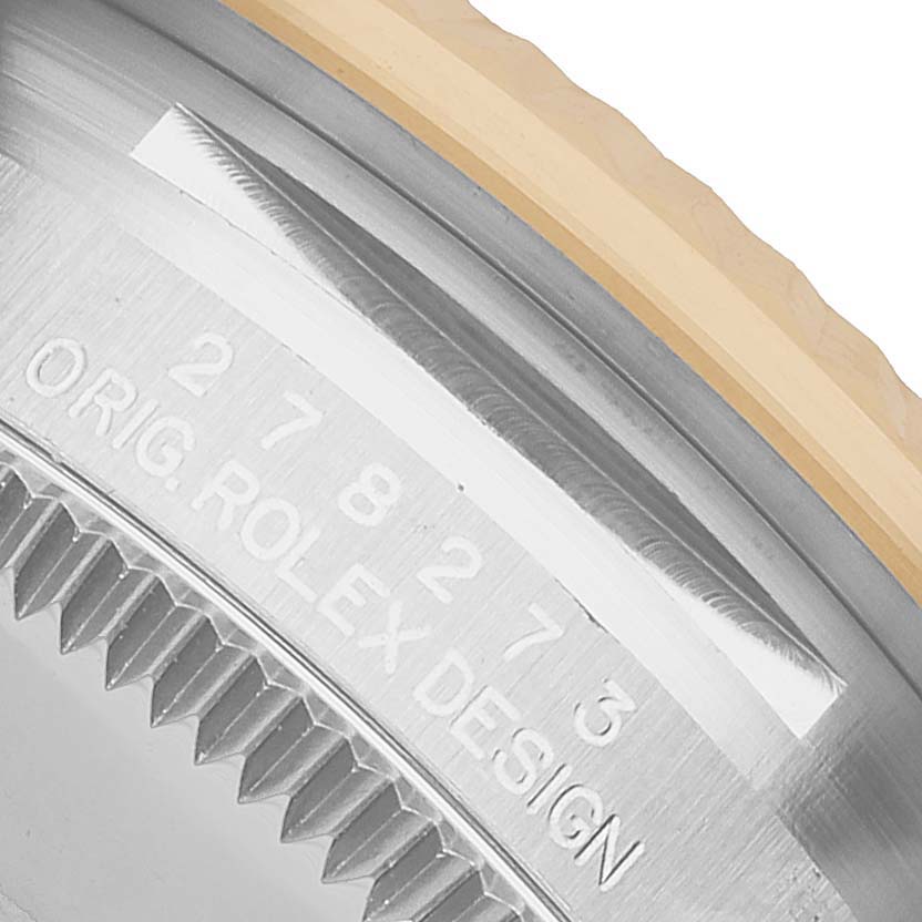The image shows a close-up of the case edge and bezel of a Rolex Mid-Size 278273 Women's Steel and Gold (two tone) Green Dial model, displaying part of its engraved design.